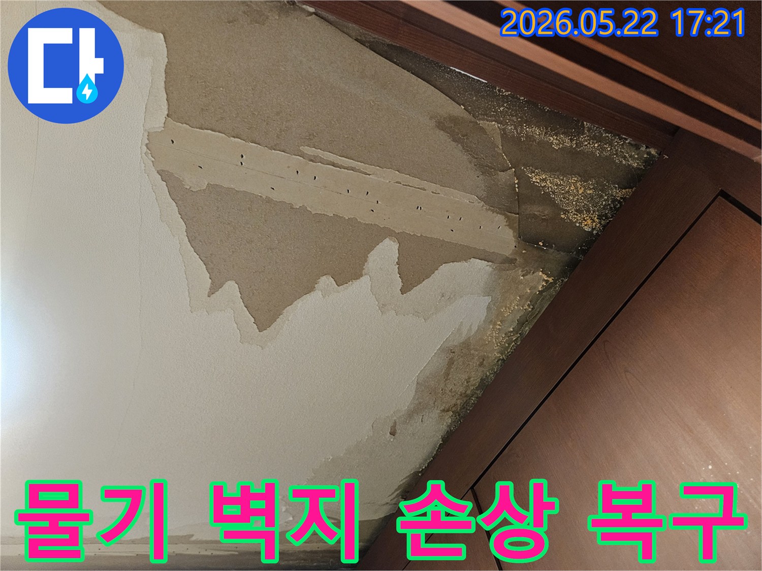 아파트 누수로 인해 벽지 하단이 물기에 젖어-심하게 들뜨고 변색된 모습을 보여주며-벽지 복구 공사가 필요한 현장입니다.
