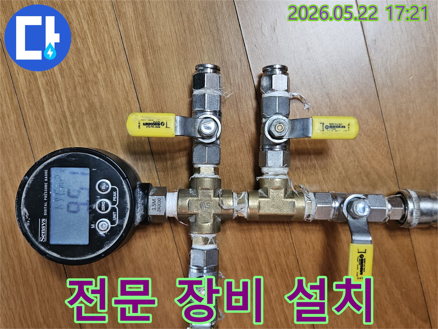 이 이미지는 누수 엔지니어가 배관에 디지털 압력 게이지와-여러 밸브를 전문적으로 연결하여-누수 탐지 준비를 마친 모습을 보여줍니다.