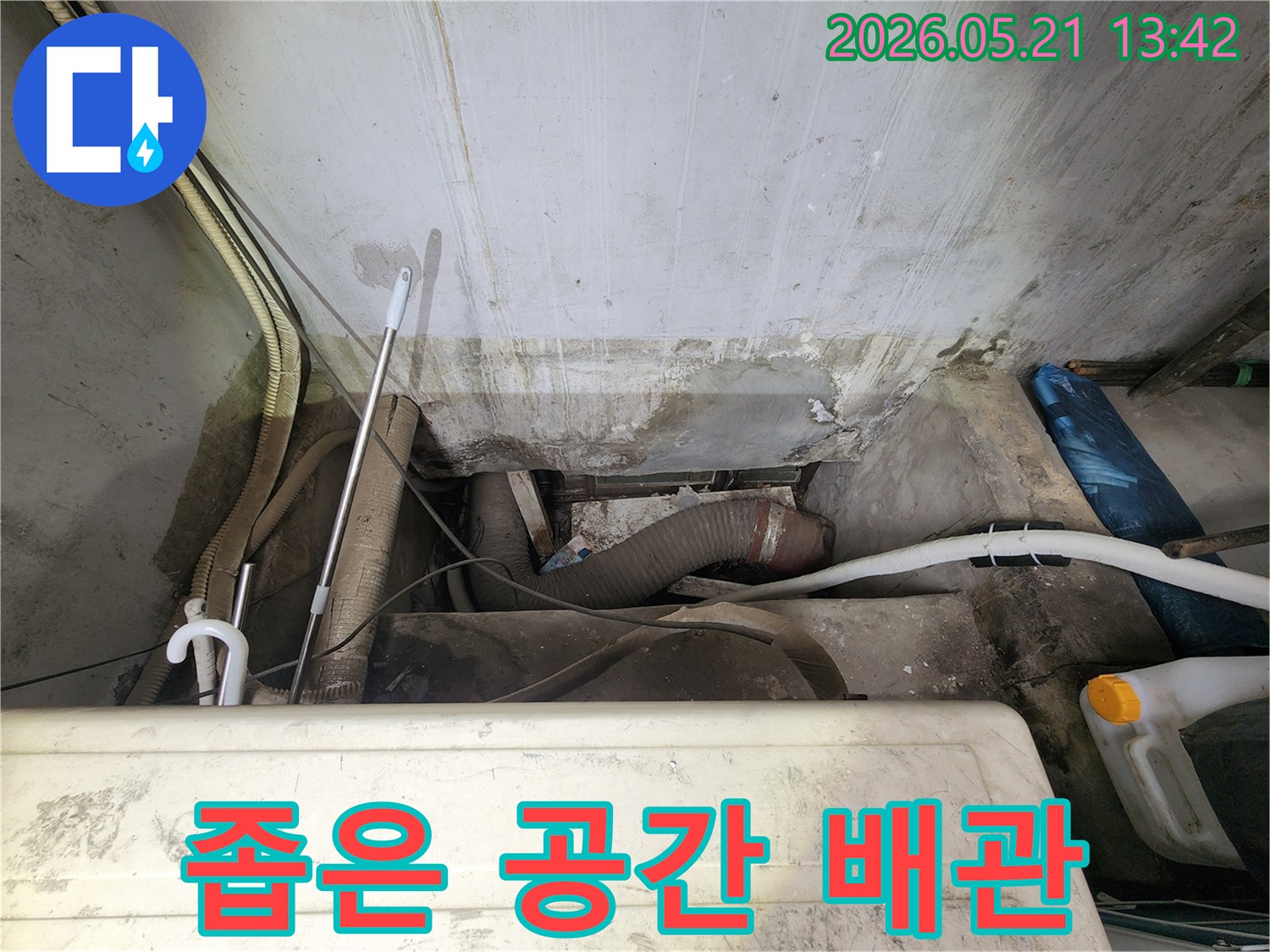 누수-전문가가-강동구-아파트의-좁은-공간에서-복잡하게-얽힌-배관들을-살펴보며-누수-여부를-정밀하게-확인하고-있는-장면입니다
