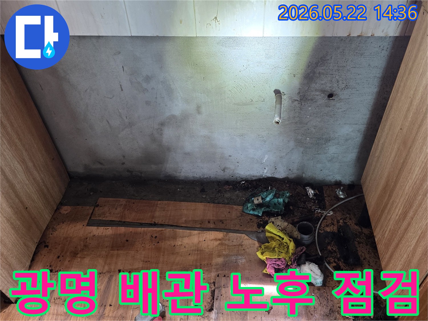 광명시 명지그린하우스텔에서-벽면 배관 주변과 바닥에 나타난-누수 흔적을-전문가가 배관 노후화를 점검하기 위해-현장을 조사하는 모습
