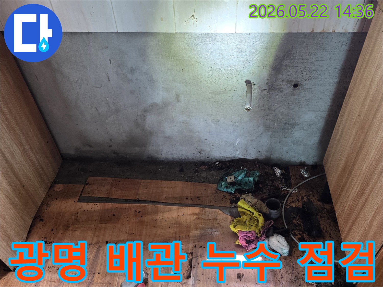 광명시 오리로 명지그린하우스텔에서-벽면과 바닥에 나타난 누수 흔적을-전문가가 배관 문제와 관련하여-정밀하게 점검하는 현장 사진