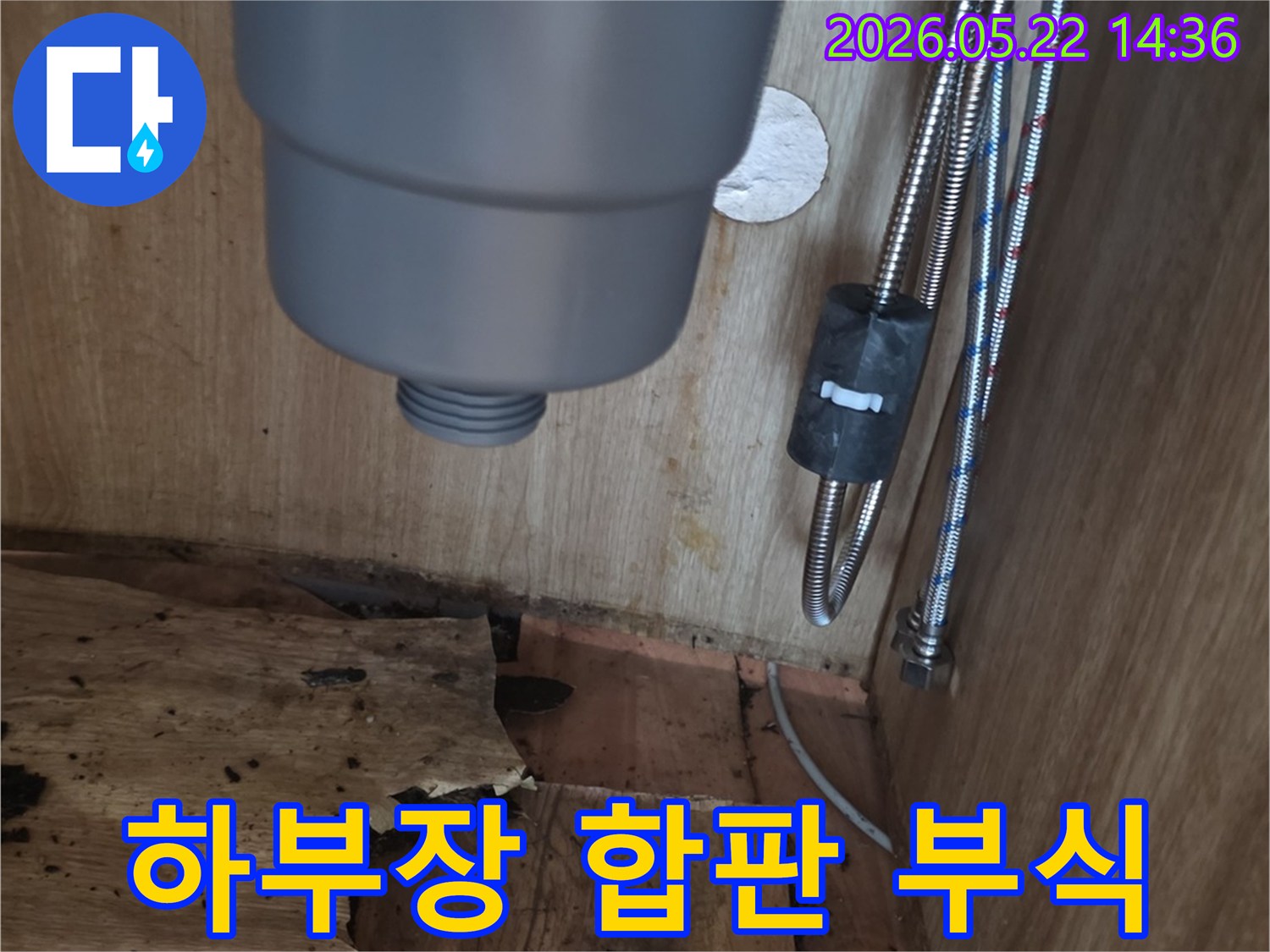 싱크대 하부장 내부의 물에 젖어 심하게 부식된 합판과-배관의 모습-누수 피해 현장을 보여주는 이미지