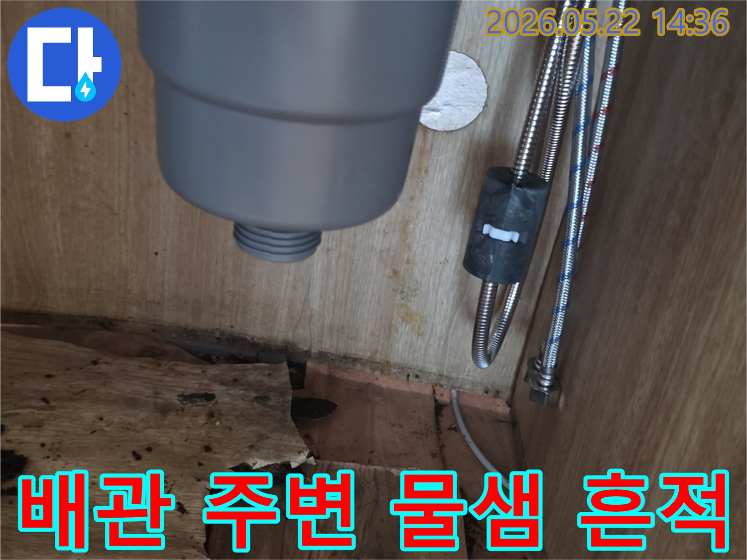 싱크대 하부장 내부의 배관 주변에 나타난-물샘으로 인한 목재 손상과-젖은 흔적을 보여주는 현장 사진