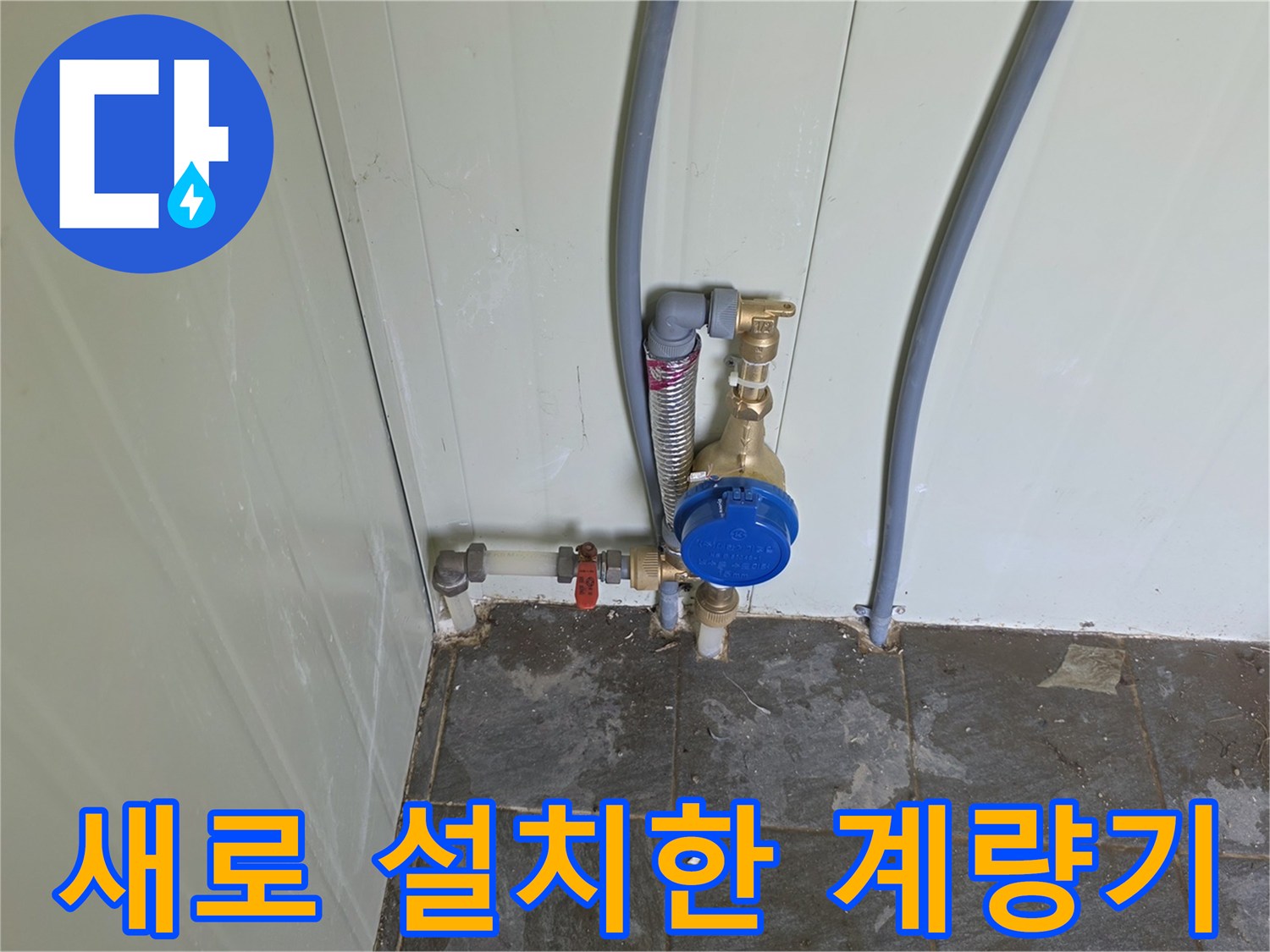 벽면 타일 아래쪽 배관과 연결된 파란색 덮개 계량기