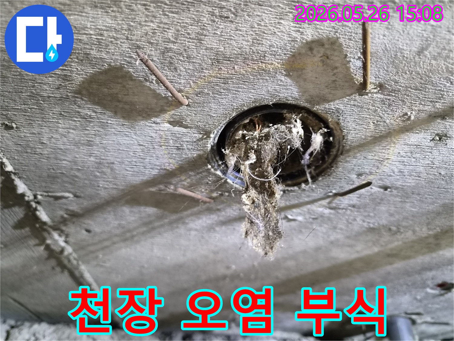콘크리트 천장 구멍에서-심각하게-오염된 이물질과-부식된 못이-보이는-누수-현장의-상황을-보여주는-사진