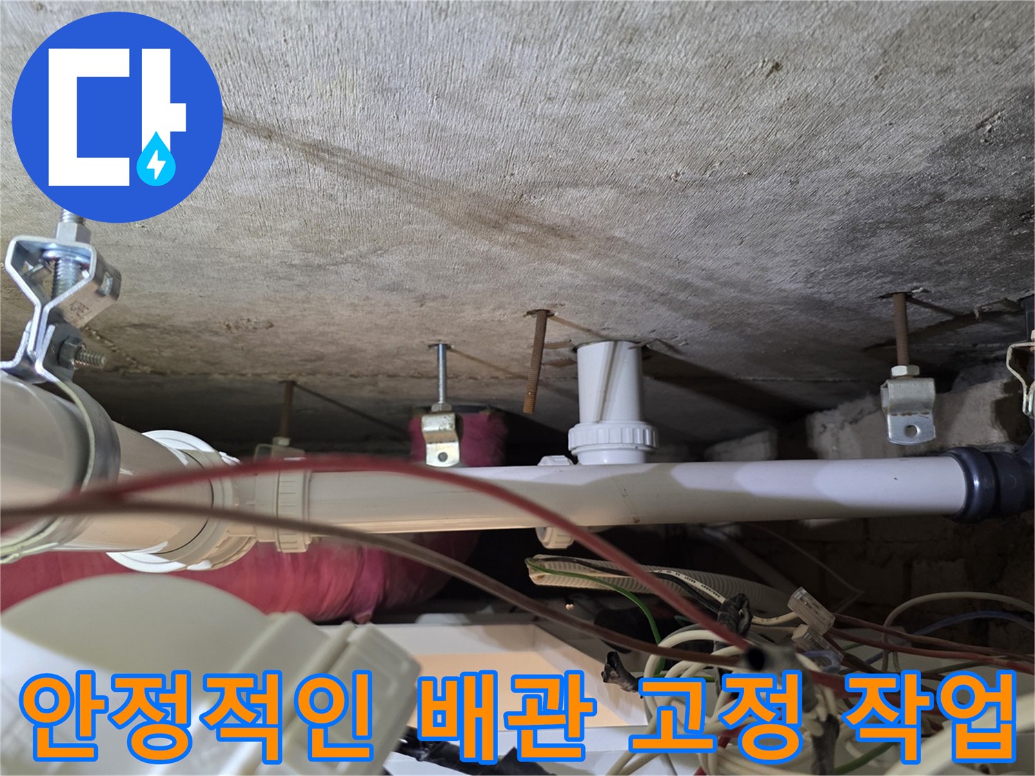 콘크리트 천장에 고정된 배관 지지대와 새 배선