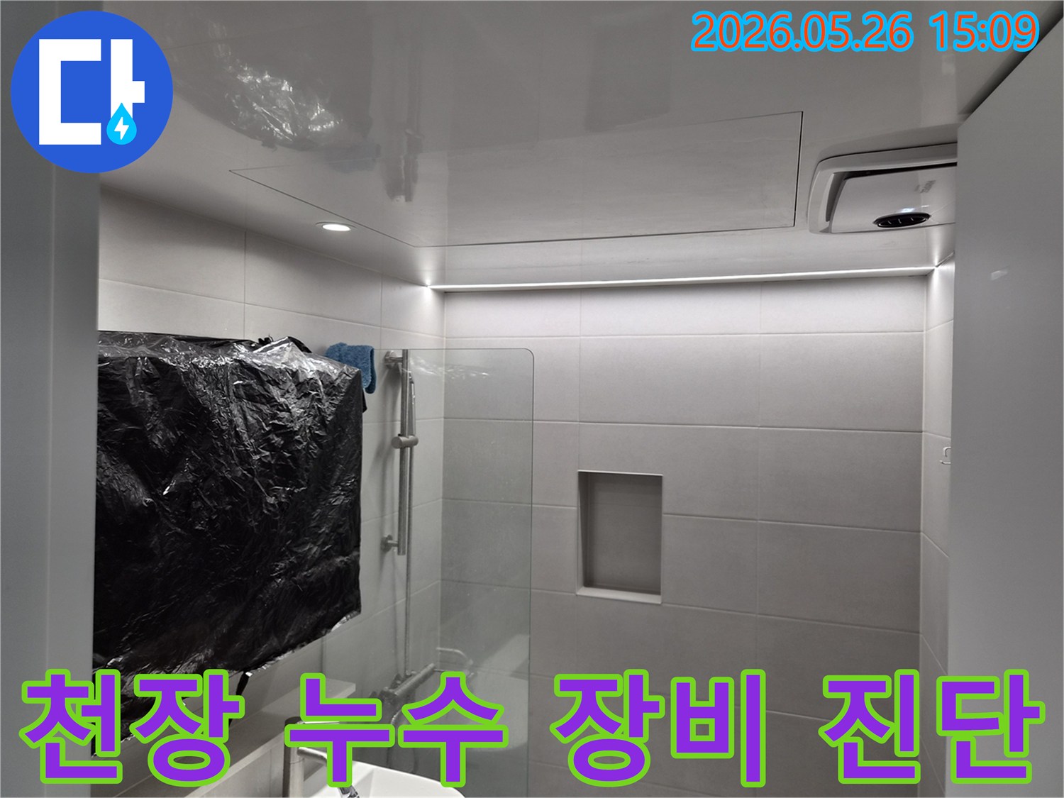 화장실 천장 누수 원인 파악을 위해-점검구를 열고-전문 탐지 장비를 활용하여 진단하는 모습