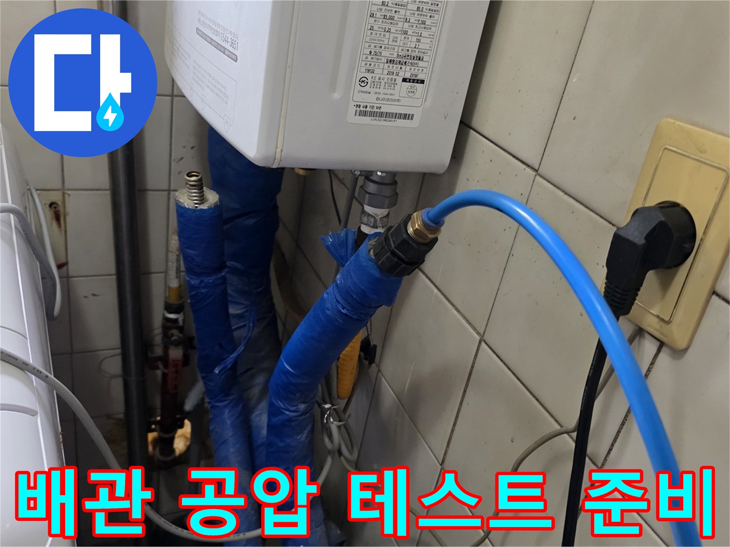 파란색 호스가 연결된 보일러실 배관 및 전기 콘센트 주변