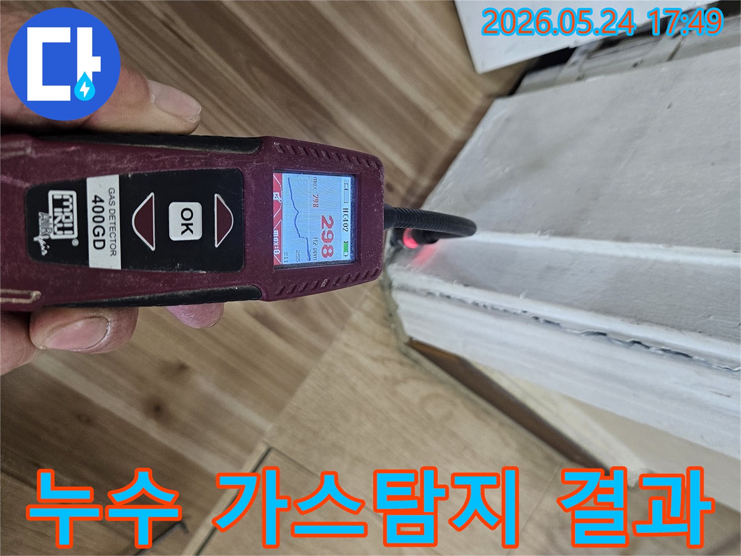 누수 엔지니어가 가스 탐지기를 사용하여 벽면과 바닥 경계에서 누수 반응을 정밀하게 확인하고 있습니다.