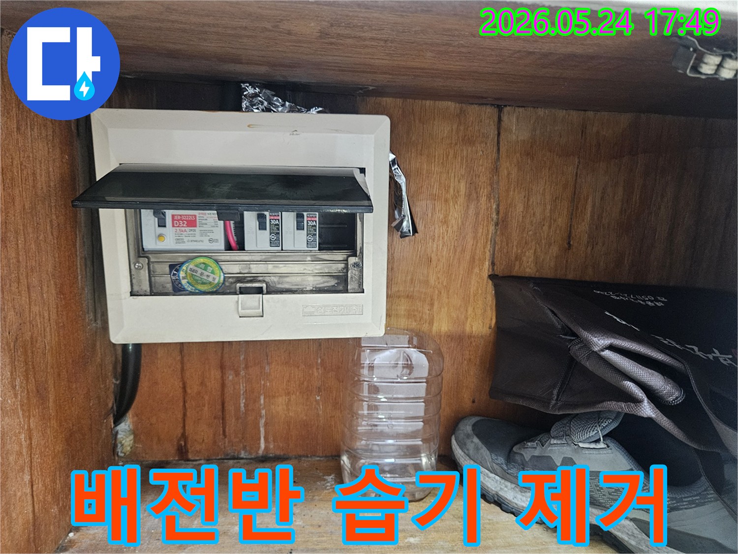 누수 전문가가 전기 배전반-주변의 습기 여부를 꼼꼼하게 점검하는 장면입니다.
