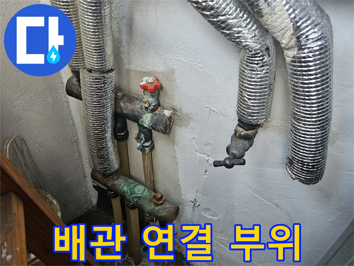 벽면에 고정된 금속 부속과 보온재가 씌워진 배관