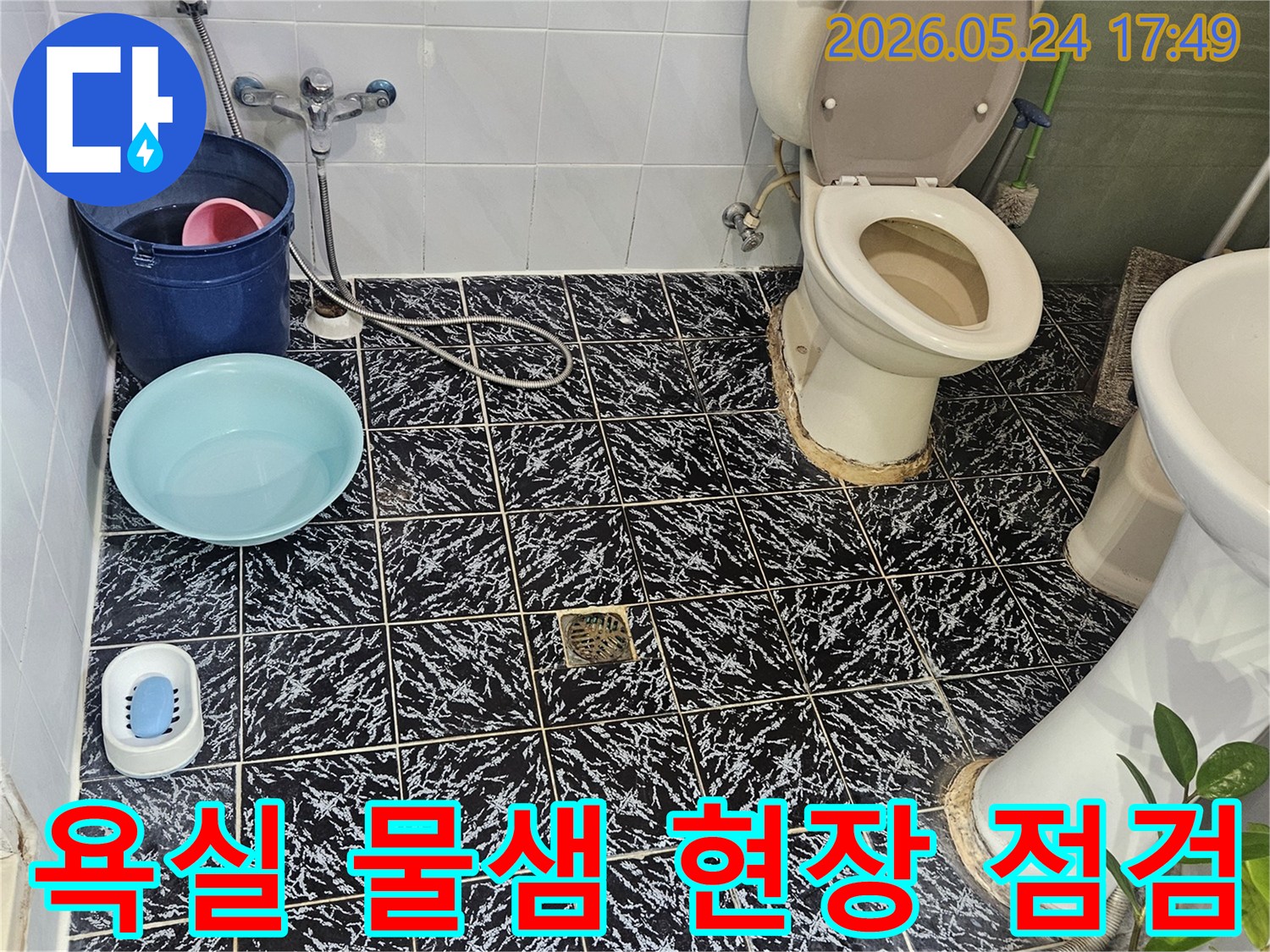 욕실 바닥에 물이 고여있는-물샘 현장을-전문가가 꼼꼼히 점검하고 있습니다