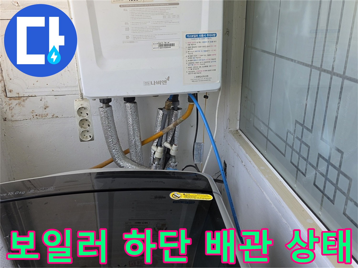 보일러 아래쪽의 은색 보온재로 감싸진 급수 및 온수 배관 연결 부위 모습
