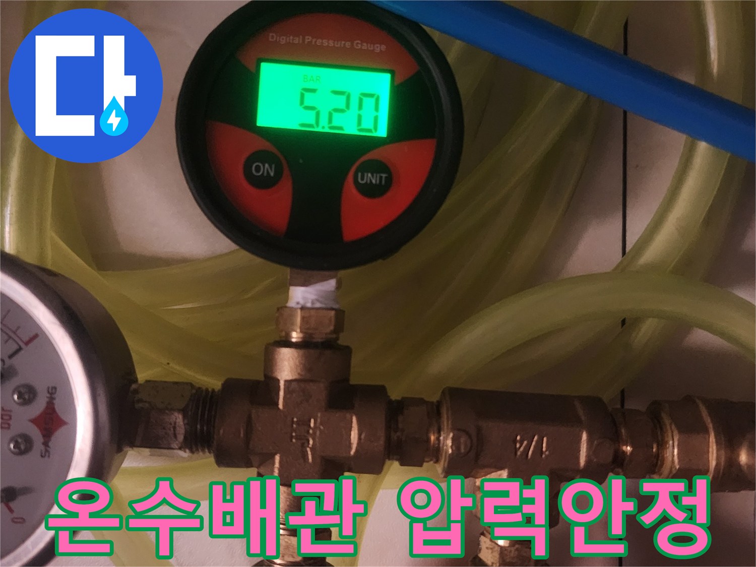이 이미지는 주거 공간의 온수 배관에서-누수 발생 여부를 정밀하게 판단하기 위해-디지털 압력 측정 장치를 사용하여-압력의 안정성을 확인하는 과정을 보여줍니다.