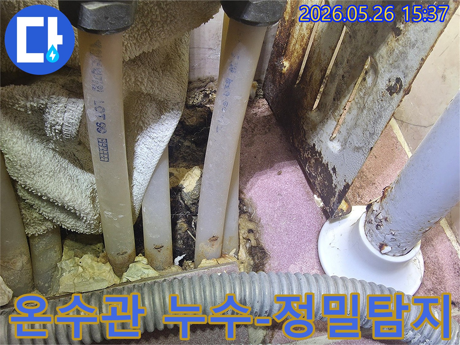 이 이미지는 온수관 주변에서 발생한 물샘-누수 흔적과 부식된 금속을 상세히 보여줍니다.