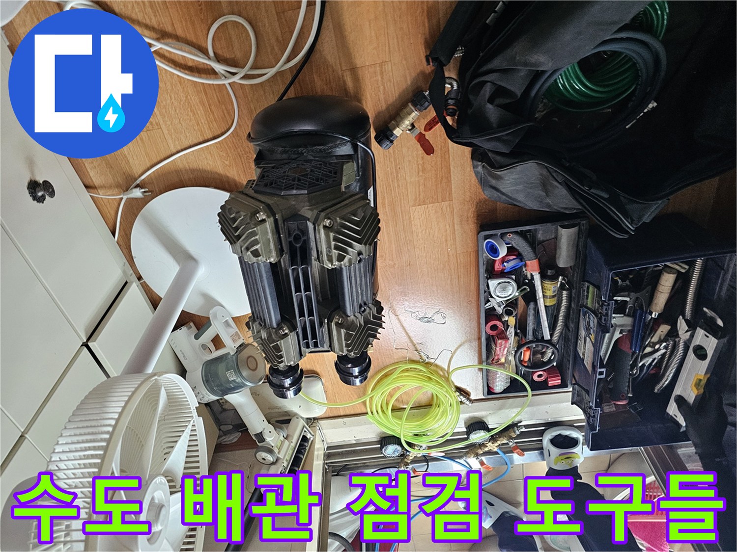 싱크대 밑 작업 공간에 배치된 컴프레셔와 각종 배관 연결 부속들