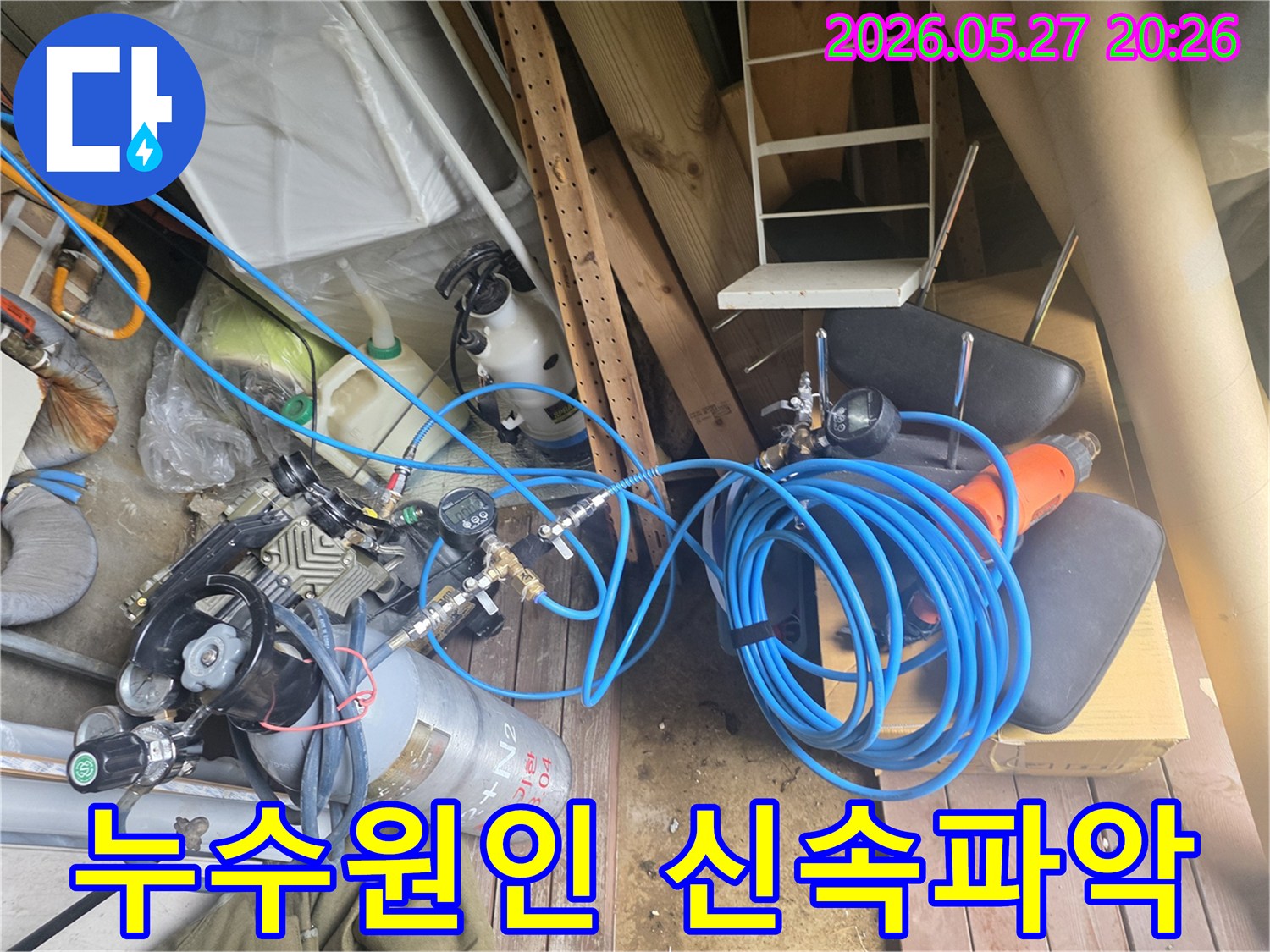 누수 원인을 신속하게 파악하기 위해 사용되는 압력 측정 장비와 가스 실린더-그리고 연결된 파란색 고압 호스들이 현장에 배치된 모습입니다.