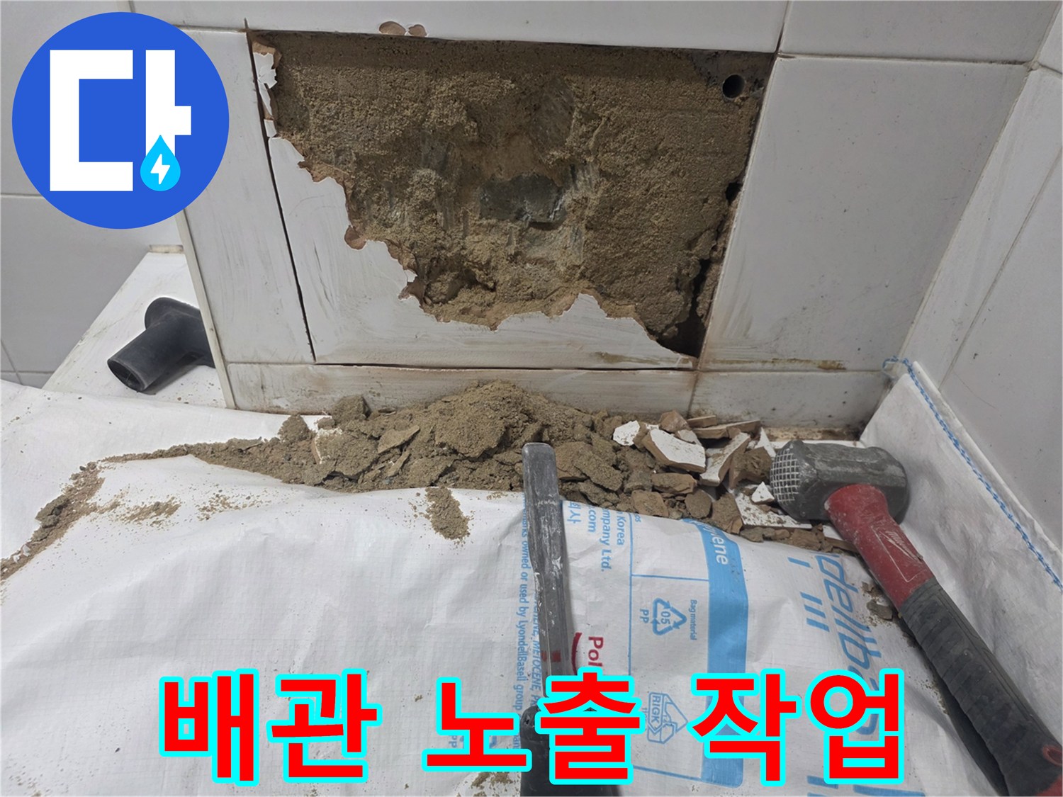 벽 내부 배관 접근을 위해 타일과 콘크리트를 파쇄한 현장 모습