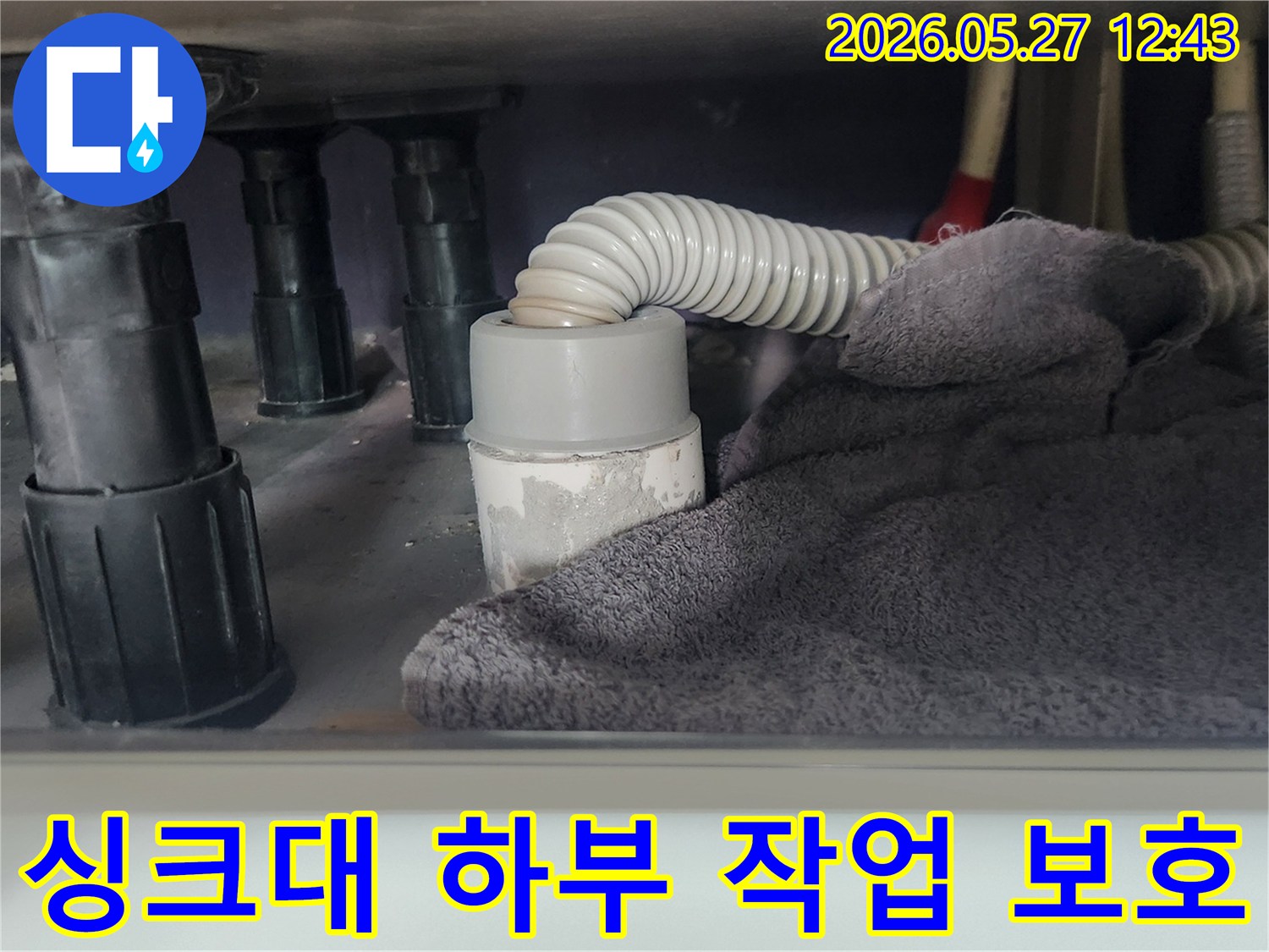 싱크대 배관 작업 전-하부 공간을 보호하고-이물질 유입을 차단하기 위해-수건을 놓아둔 모습입니다