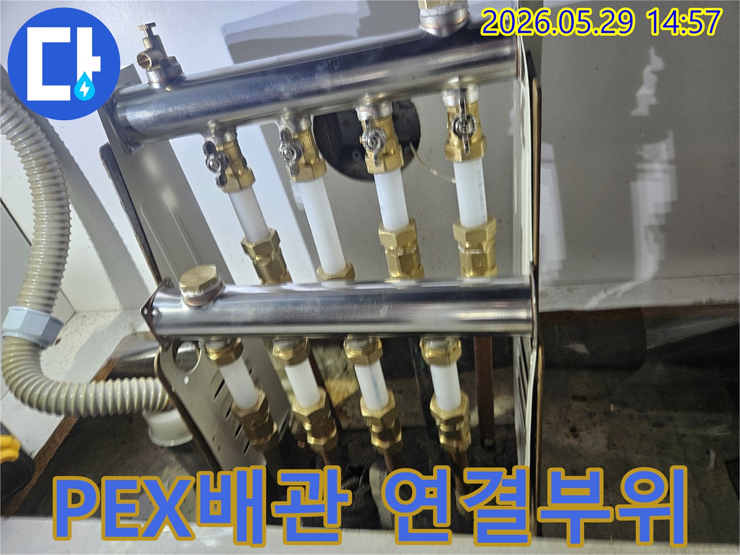 PEX 배관과 황동 밸브로 구성된 난방 분배기의-누수 지점을 정확히 파악하기 위한 현장 사진입니다