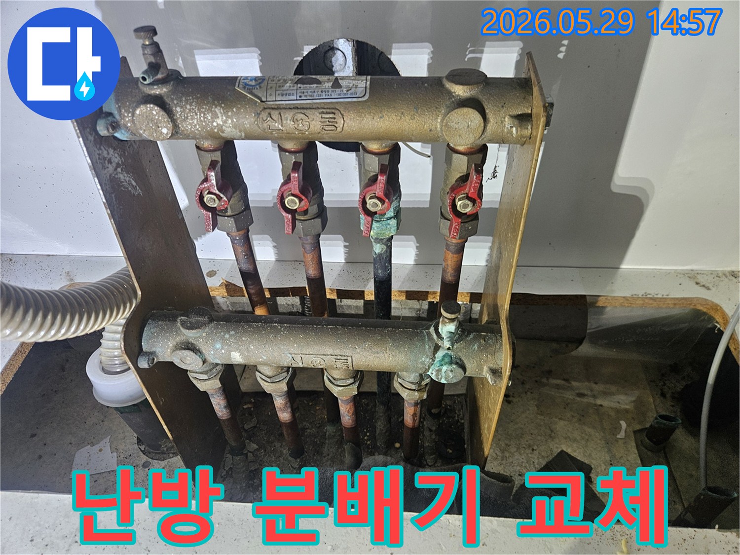 오래된 아파트의 난방 분배기에서-심각한 부식과 함께 누수 흔적이 발견되어-전문가가 교체 작업을 준비하고 있습니다.
