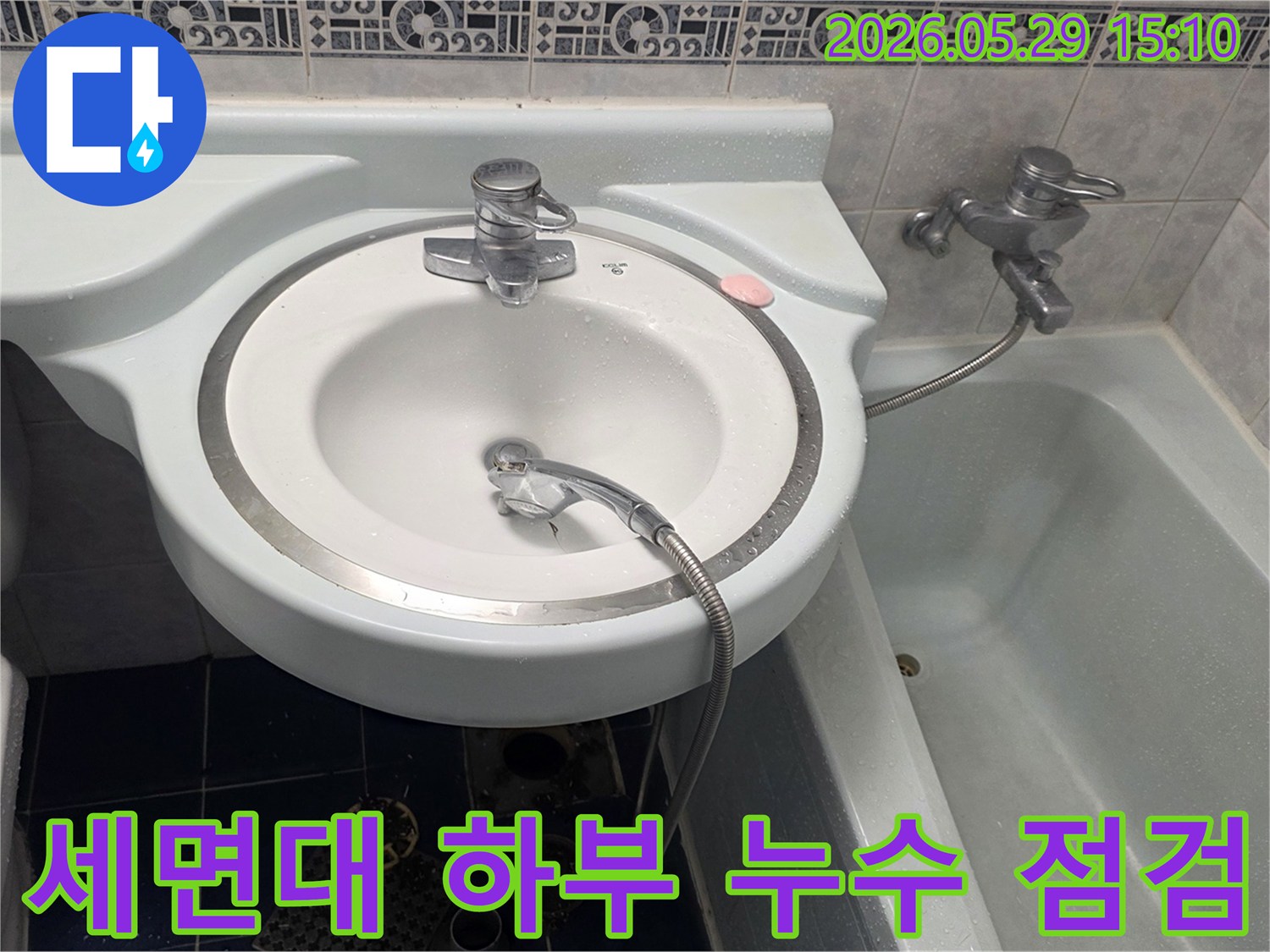 욕실 세면대 아래에서 물이 떨어지는 증상으로-인한 누수 현장을-전문가가 점검하는 모습입니다.