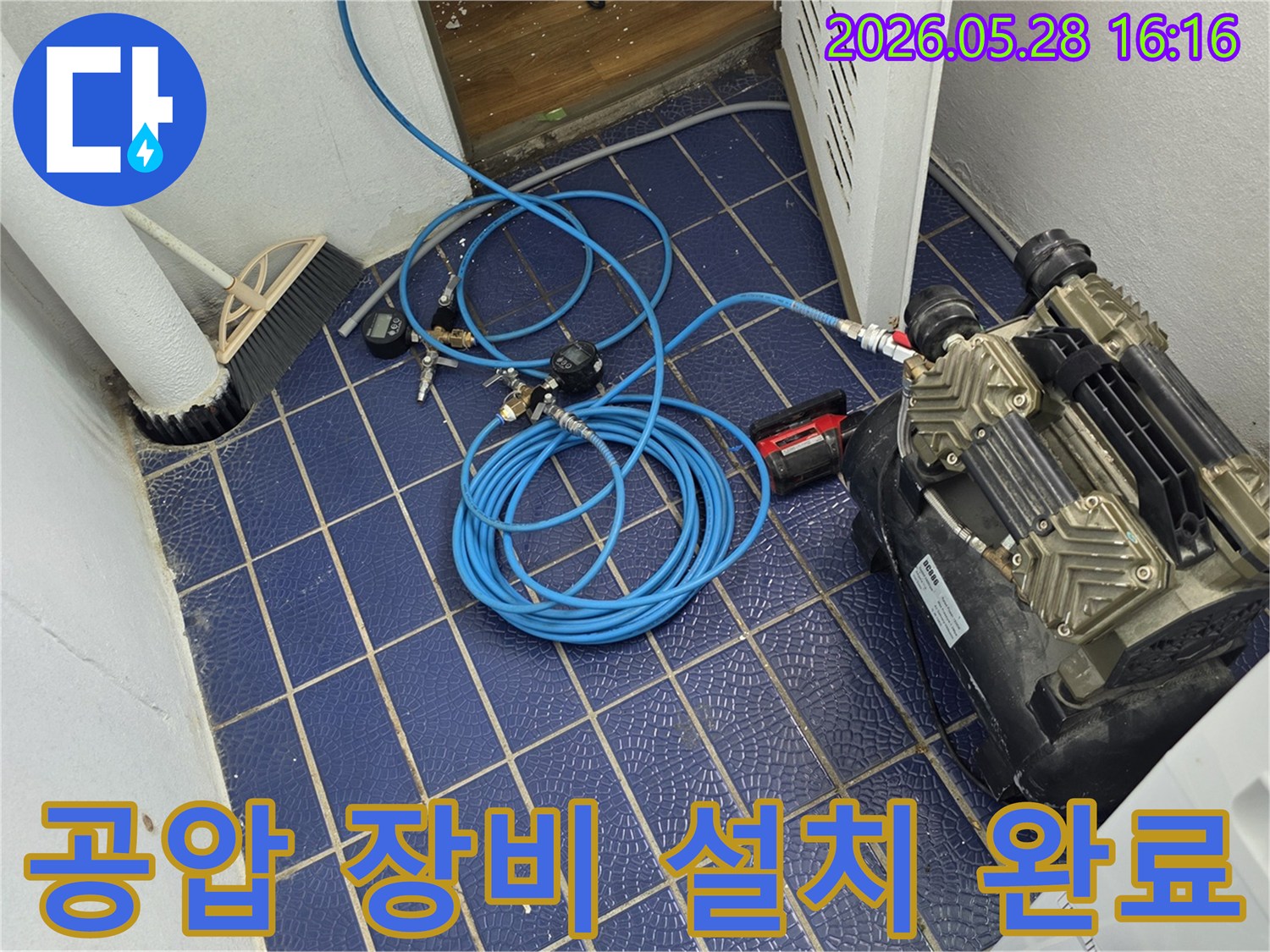 누수-탐지를-위해-배관에-연결된-공압-장비와-압력-게이지-그리고-파란색-호스가-놓여있는-작업-현장