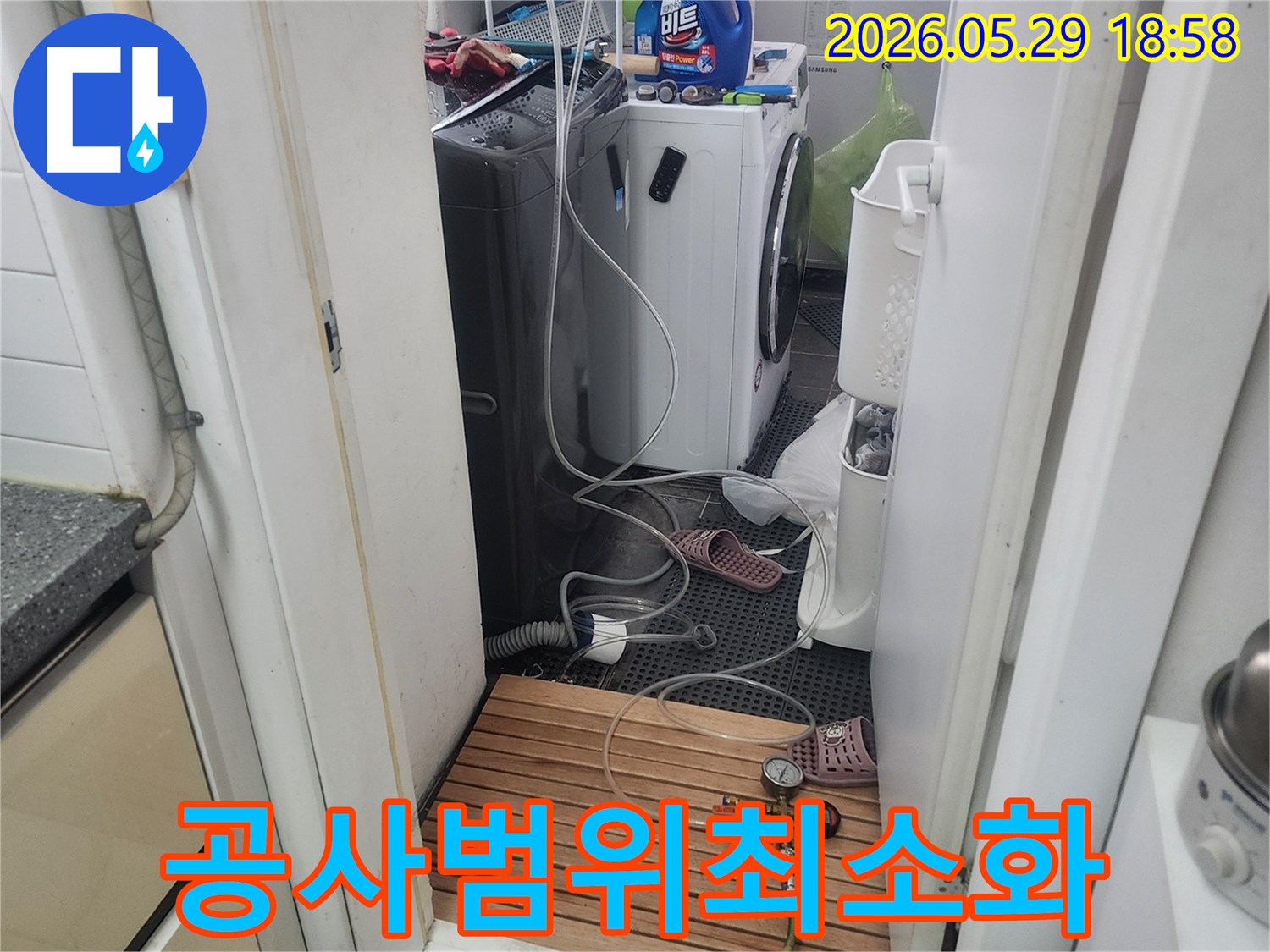 세탁실-내부에서-누수-탐지를-위해-배관에-연결된-압력-측정-장비로-정밀-진단하는-모습