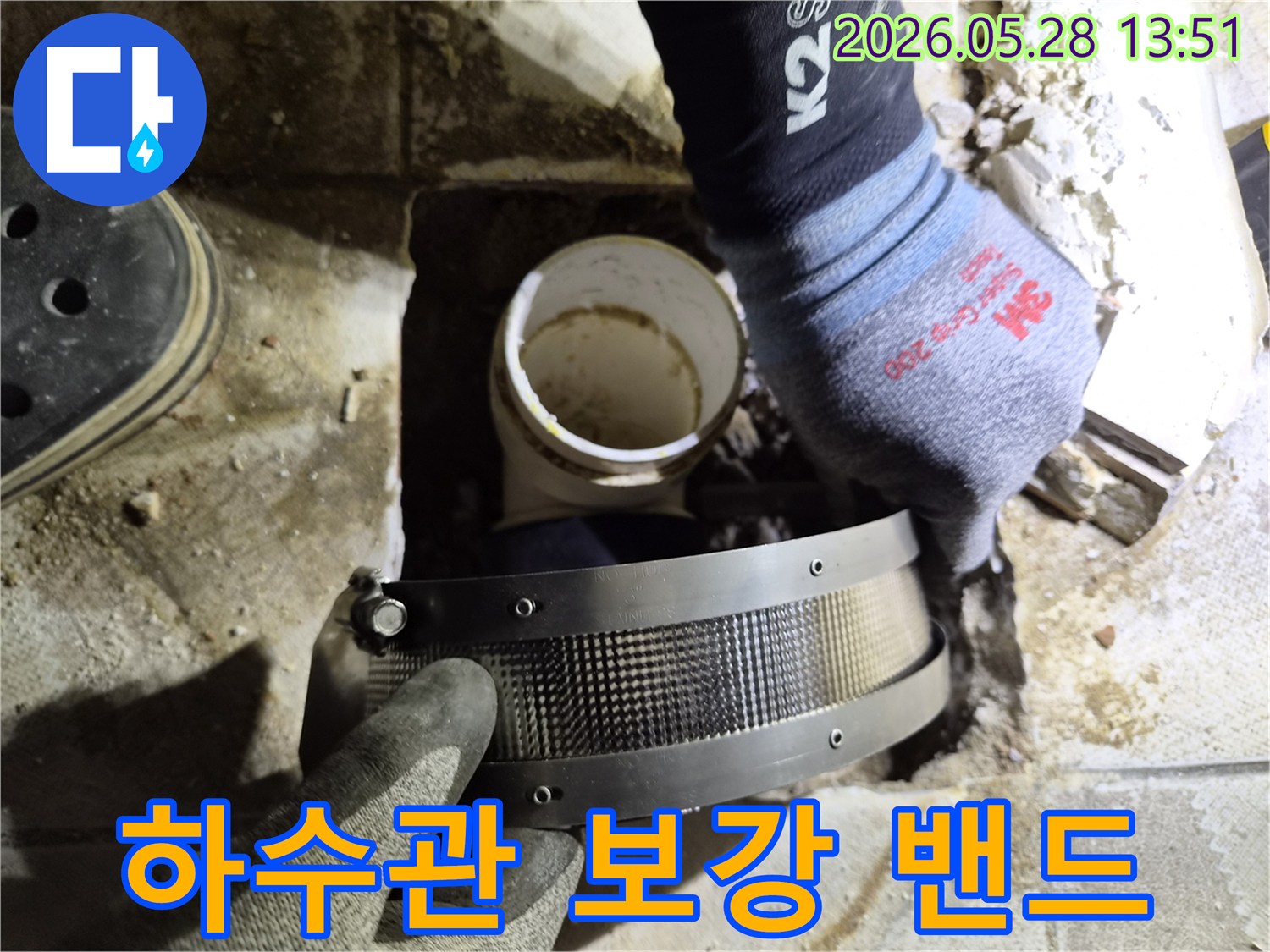 숙련된 작업자가 보호 장갑을 착용하고-하수관의 취약한 연결 부위에-보강 밴드를 설치하는 중입니다