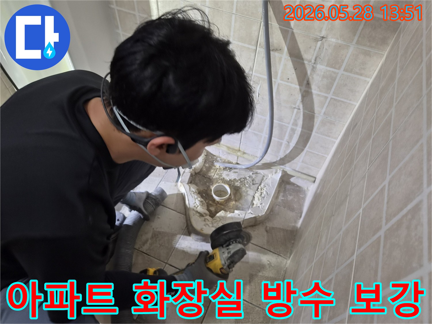 전문 엔지니어가-안전 장비를 착용하고-아파트 화장실 바닥의-배관 주변 누수 지점을-그라인더로 정밀하게 제거하는-보수 작업 현장