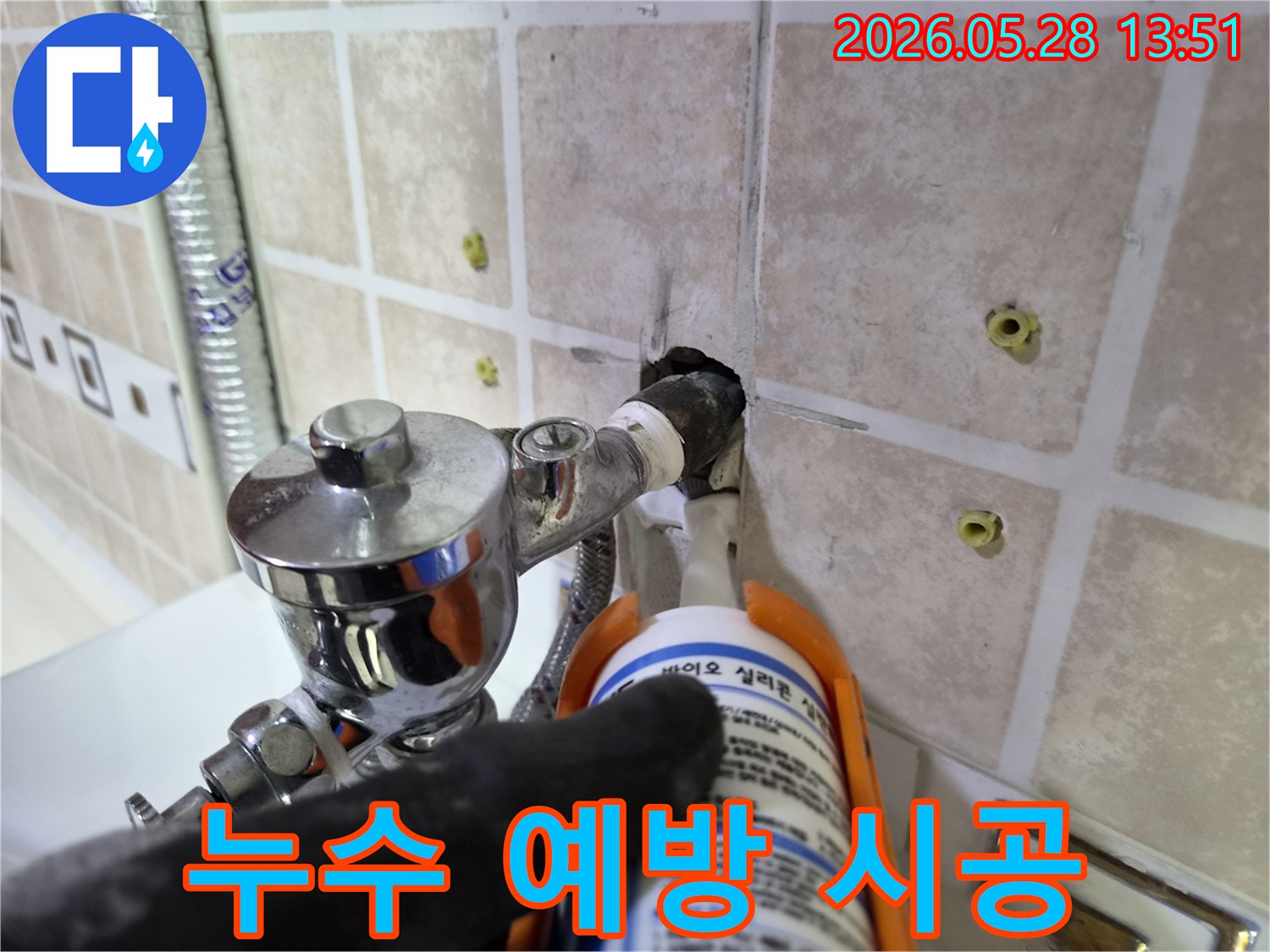 타일 벽면의-수도 배관 주변-누수 지점을-실리콘으로-완벽하게-실링하는-과정을-보여줍니다.