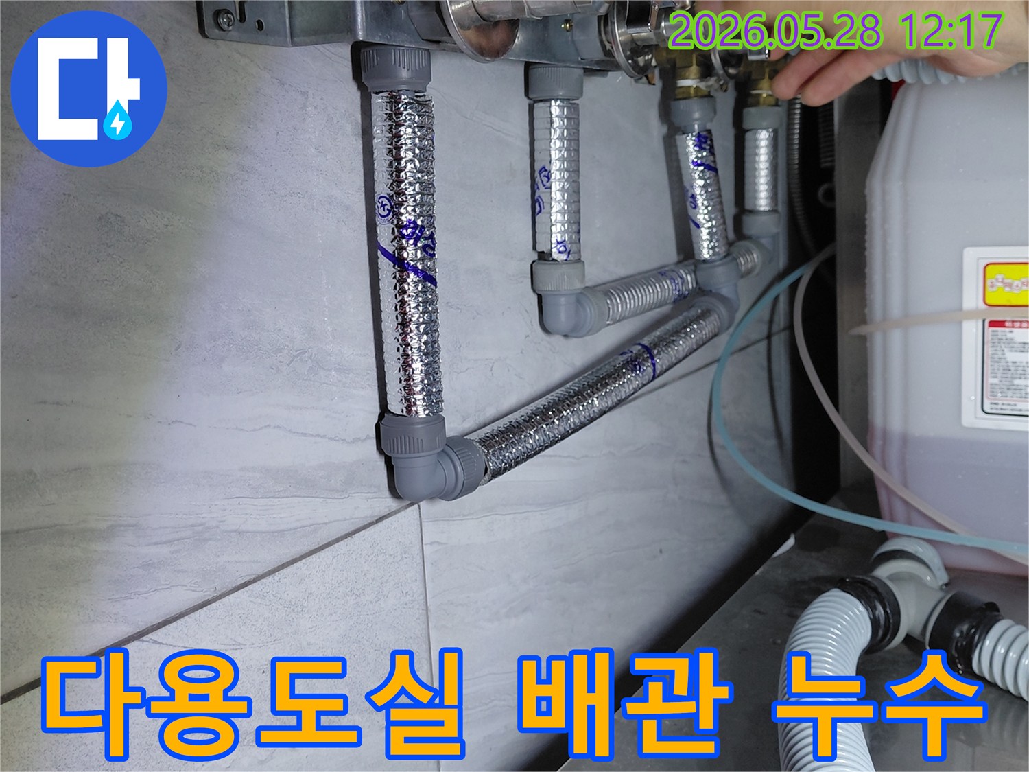 다용도실 바닥의 배관과 밸브에서-누수 여부를 확인하기 위해-전문가가 세심하게 탐지하는 모습