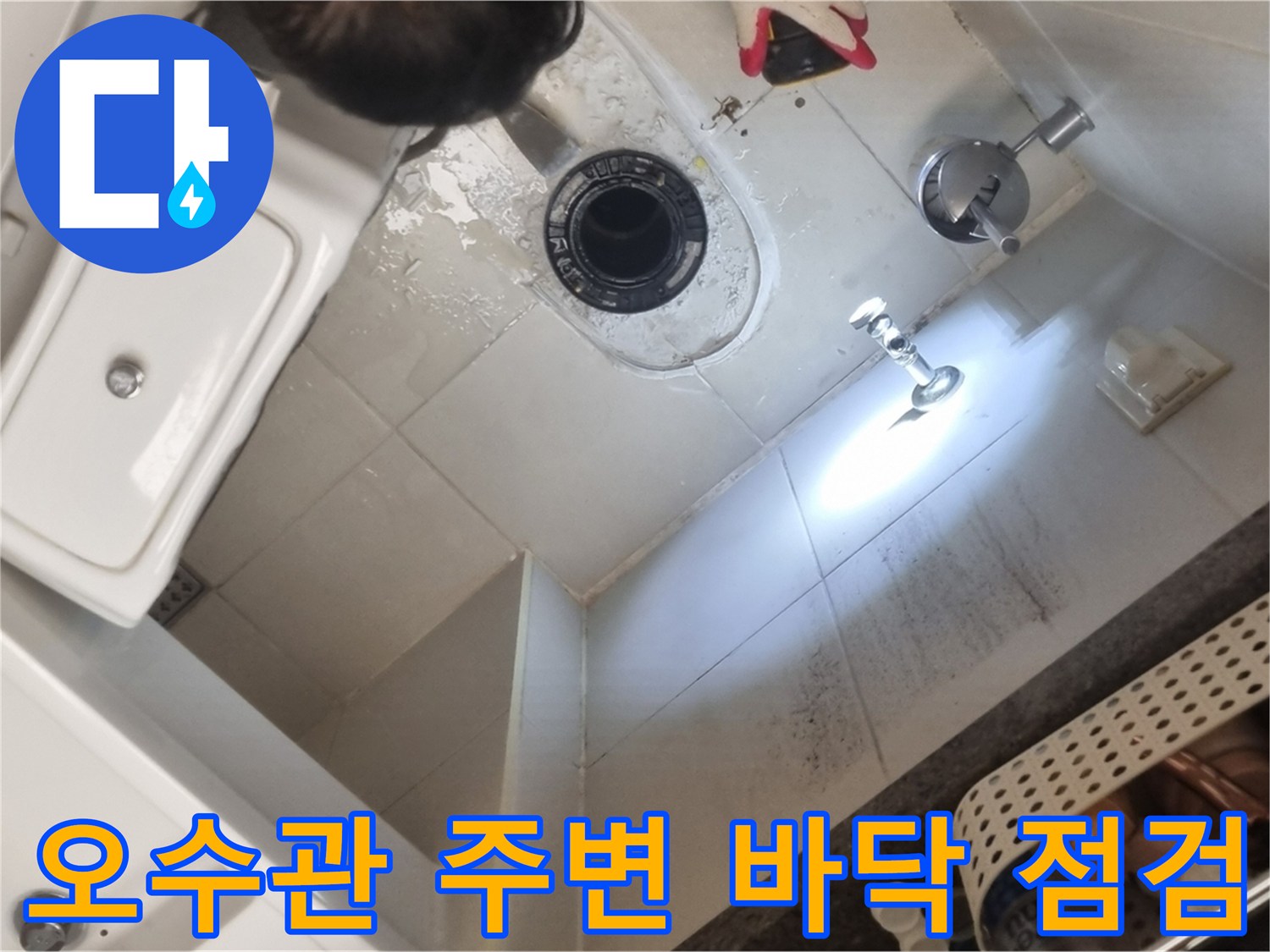 변기 아래 오수관 입구와 타일 사이의 습기 상태를 촬영한 사진입니다.