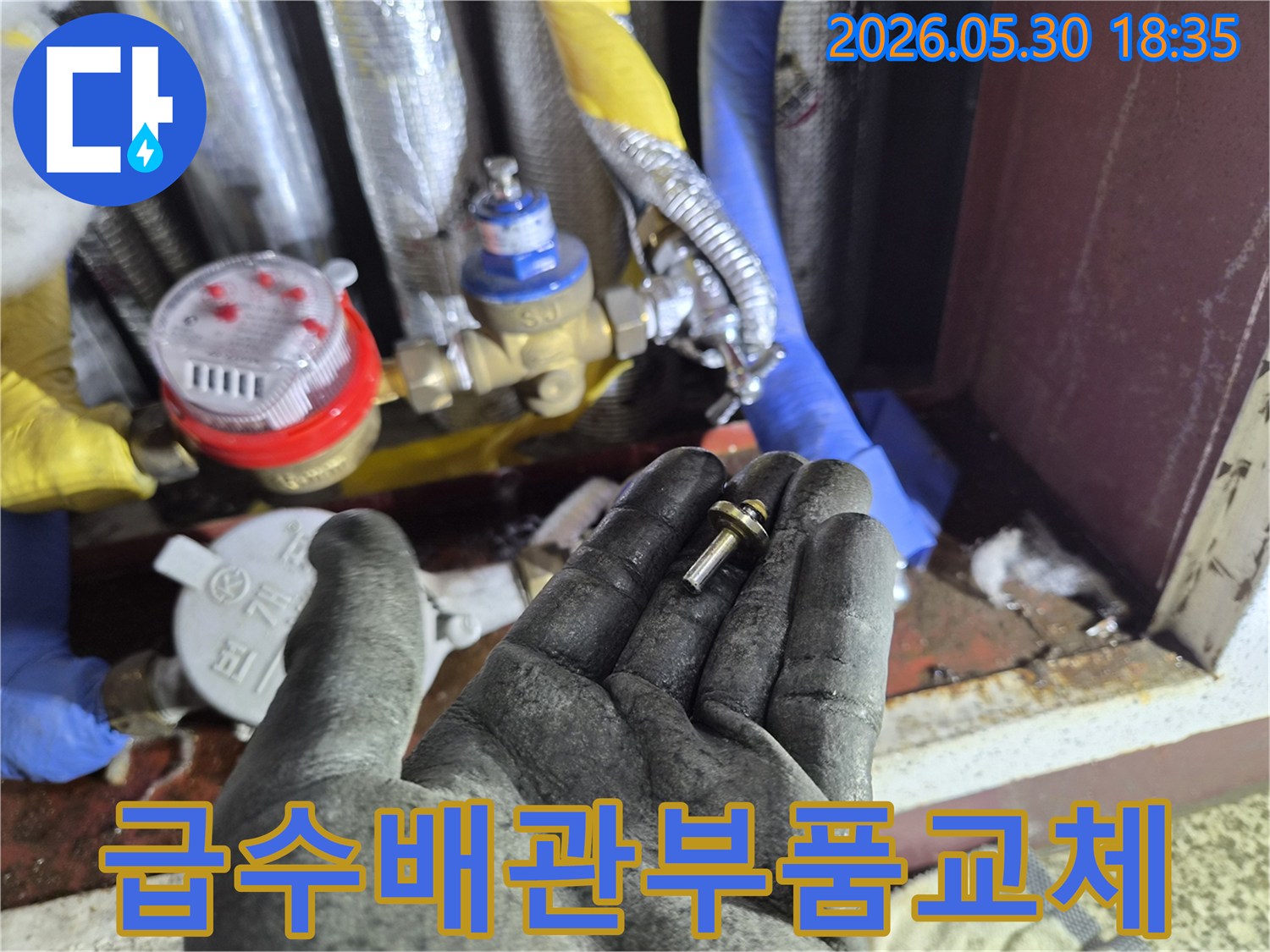 상가-급수-배관-누수-현장에서-발견된-손상된-배관-부품을-작업자가-확인하는-모습