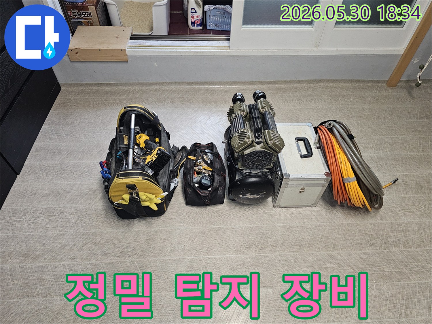 아파트-누수-현장에서-정밀한-탐지를-위해-준비된-다양한-전문-장비와-공구들이-바닥에-정렬되어-있는-모습입니다.