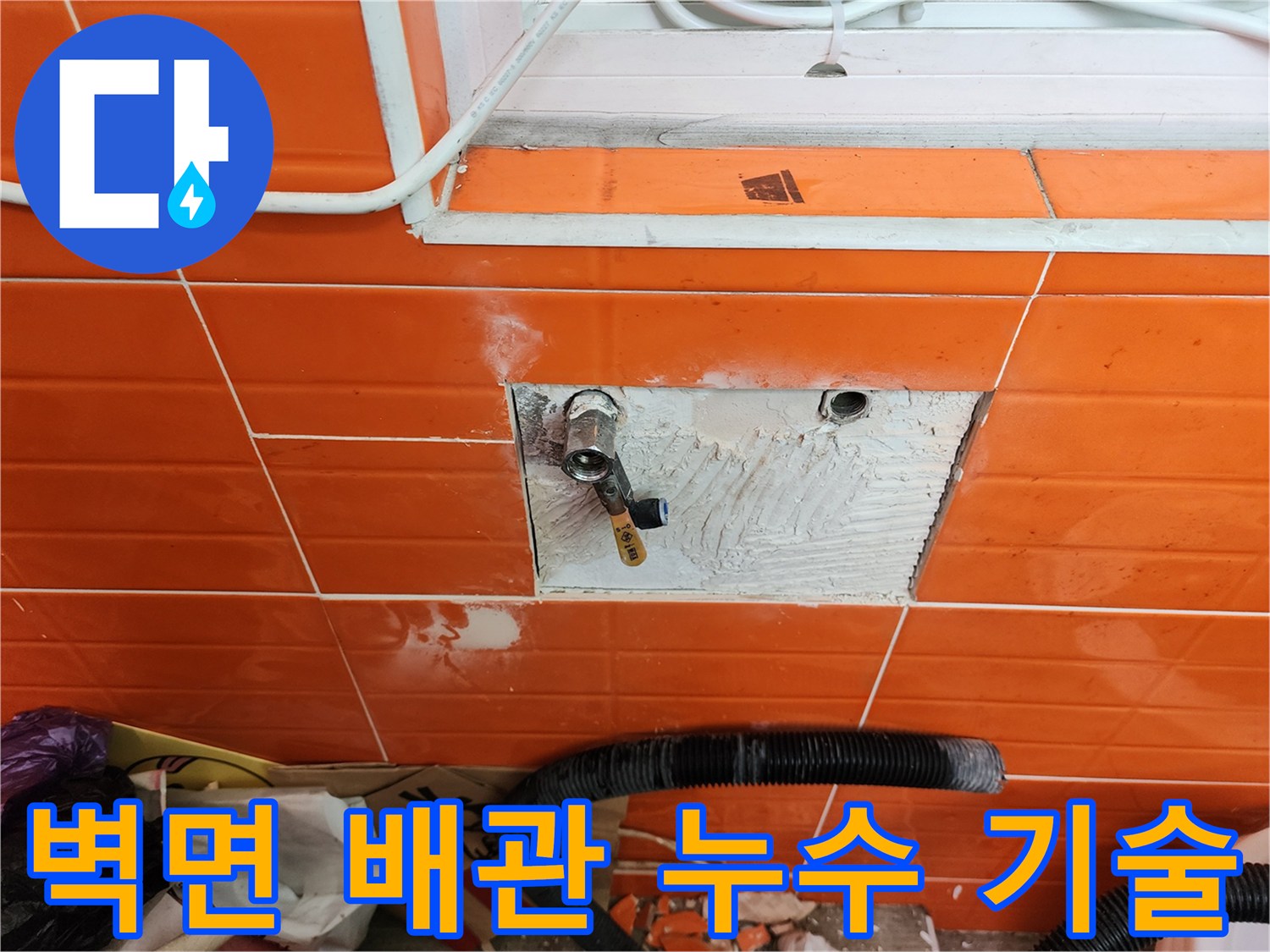오렌지색 타일 벽면의-배관 누수를-전문 기술로 해결하기 위해-타일을 제거하고-배관을 수리하는 작업 현장