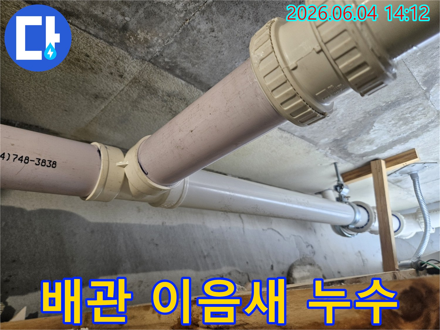 아파트 천장 배관의 이음새 부분에서 누수가 의심되어-전문가가 원인을 파악하기 위해 면밀히 점검하는 모습입니다