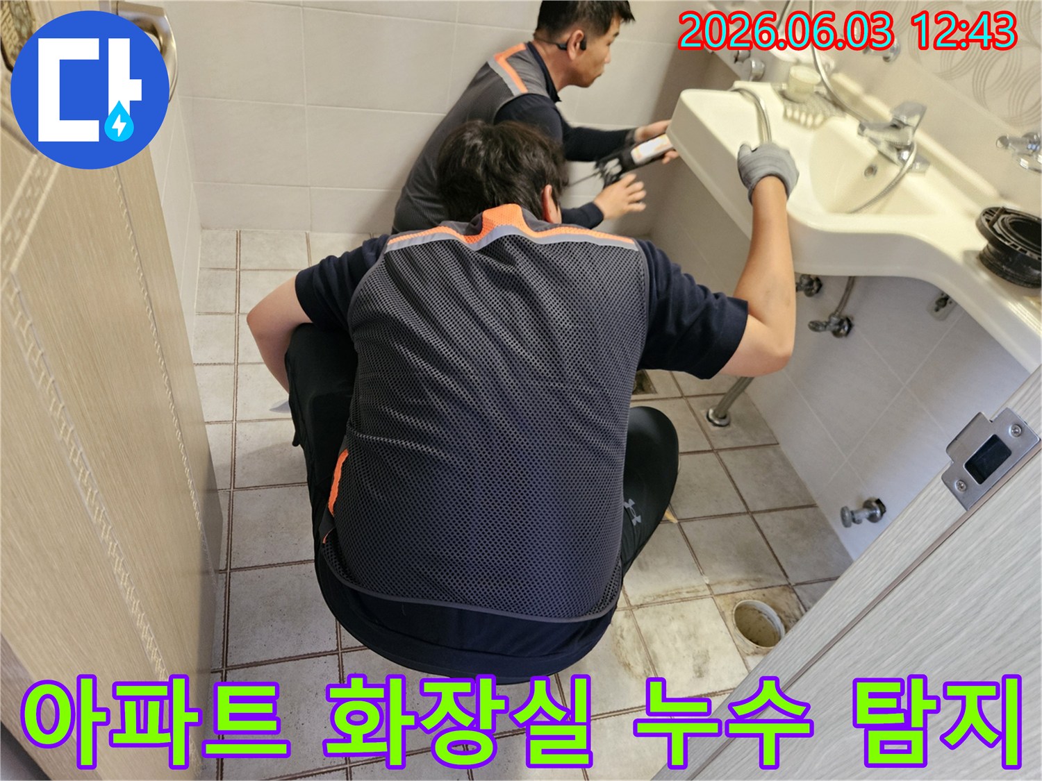 서울 중랑구 아파트 화장실에서-누수 전문가 두 명이-정밀 탐지 장비를 이용해-누수 지점을 확인하는 모습