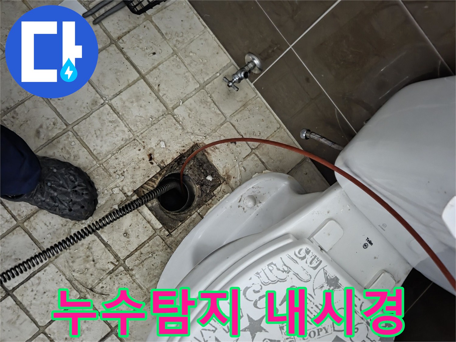 화장실 바닥 배수구에-내시경 장비가-삽입되어-누수 원인을-탐지하고-배관 상태를-확인하는-전문가의-작업 모습