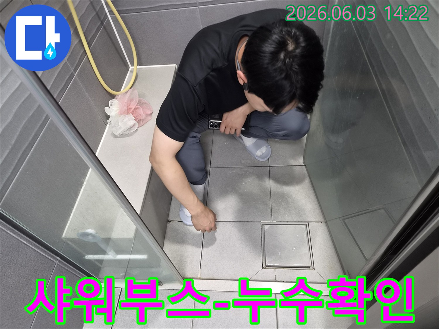 누수-전문가가-샤워부스-내부-바닥-타일의-줄눈-상태를-정밀하게-검사하며-미세-누수-지점을-탐색하는-과정