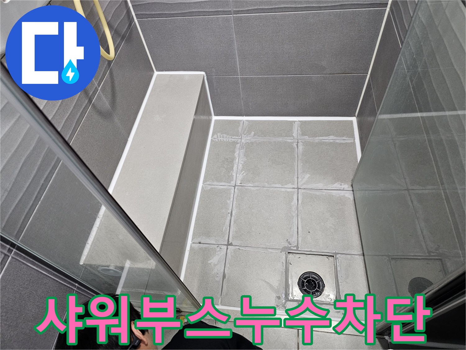 서울 강동구 샤워부스 하단에서 발생한 누수를 막기 위해-전문가가 방수 실리콘으로 보강하는 모습입니다.