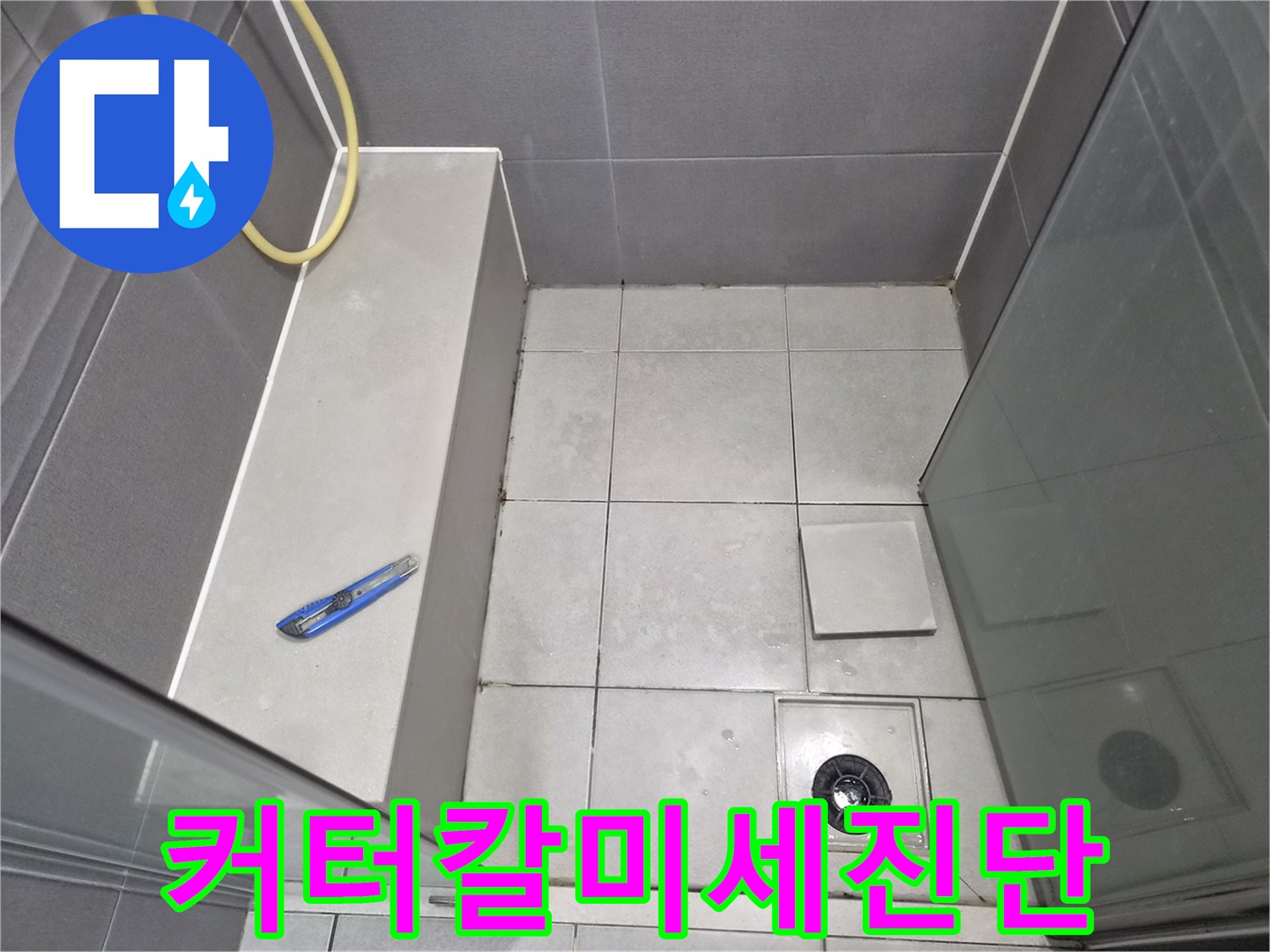 욕실-바닥-타일과-배수구-주변을-점검하며-커터칼을-활용하여-미세한-틈새의-누수-원인을-진단하는-엔지니어의-작업-현장-사진입니다.