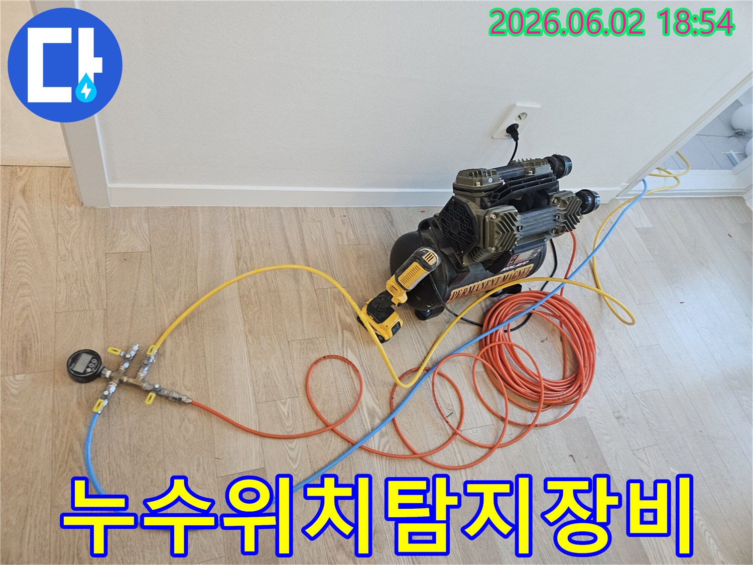 누수 지점을 정확하게 찾아내기 위해 배관에 연결된 압력 테스트 장비와 호스