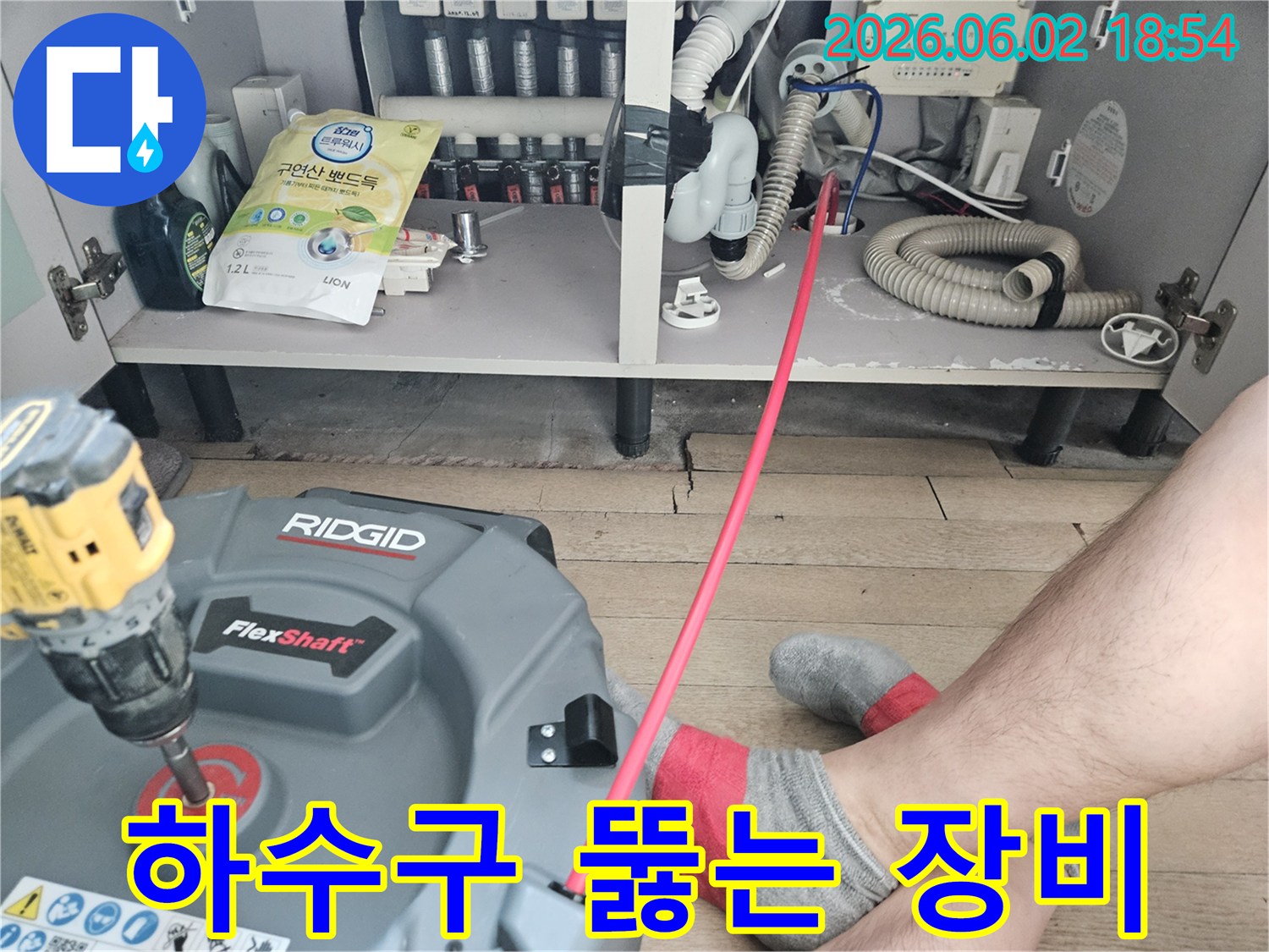 주방 싱크대 아래-배관 막힘을-해결하기 위해-전문 장비를-설치하고-작업을 시작하는 모습입니다.