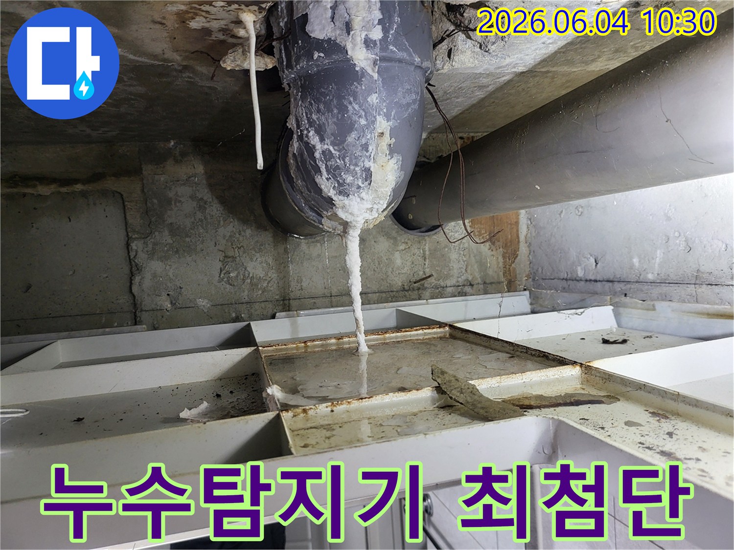 천장 배관에서 물이 새어 나와-석회질이 고드름처럼 맺히고-아래 바닥에 물이 고인 누수 현장