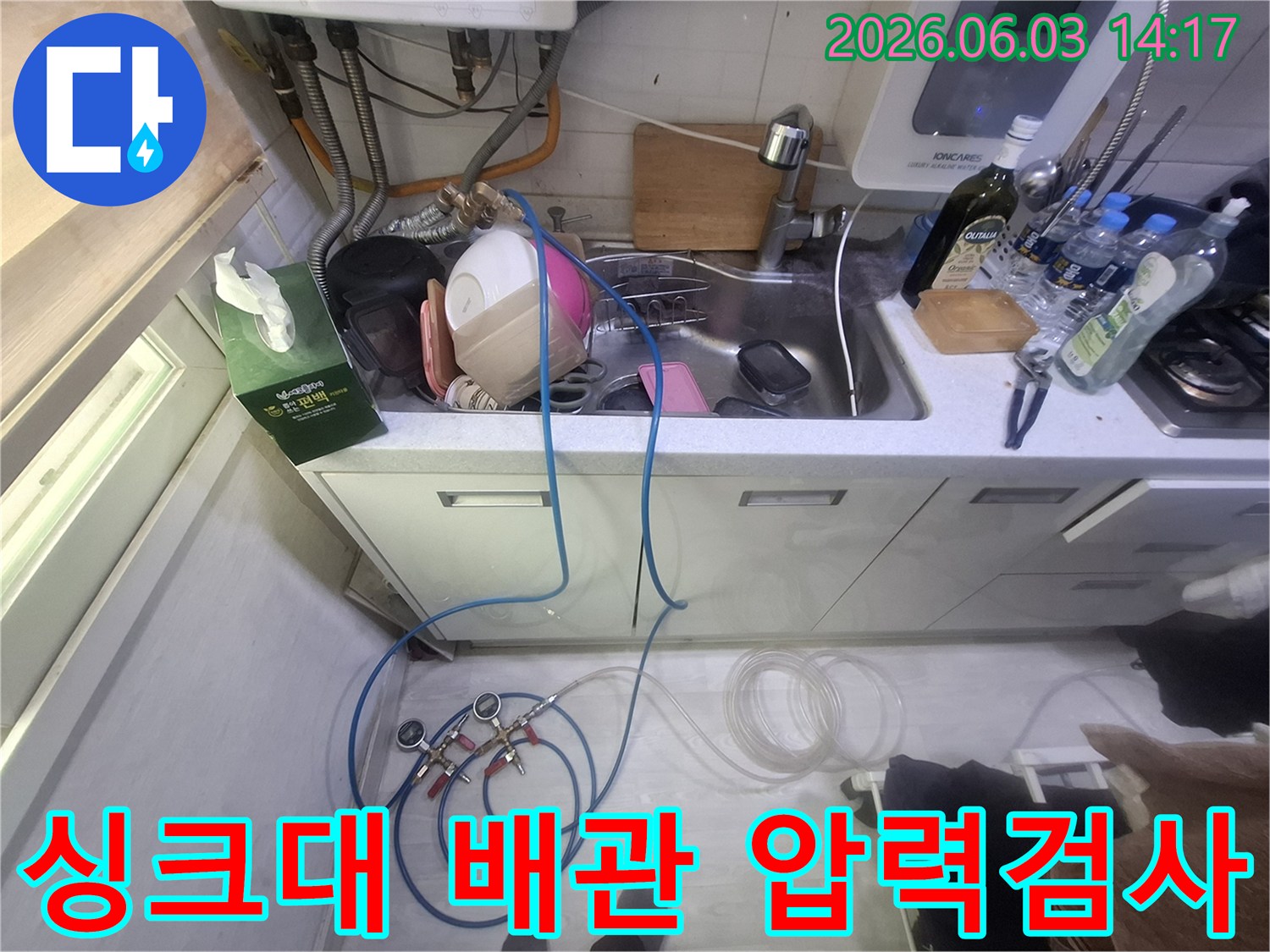 싱크대 하부 배관의-누수 여부를 확인하기 위해-정밀 압력 테스트 장비를 설치하고-점검하는 과정