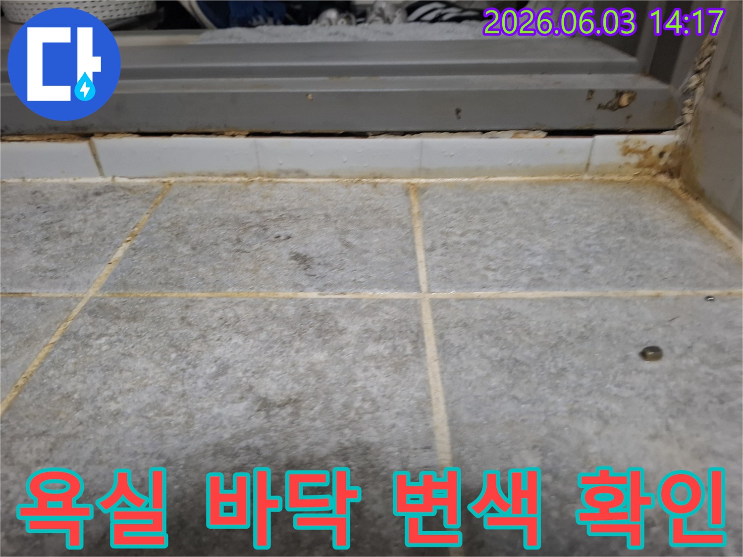욕실 바닥 타일과 문턱 경계면에서 발견된-오랜 누수로 인한 심각한 변색과 오염의 증거입니다.