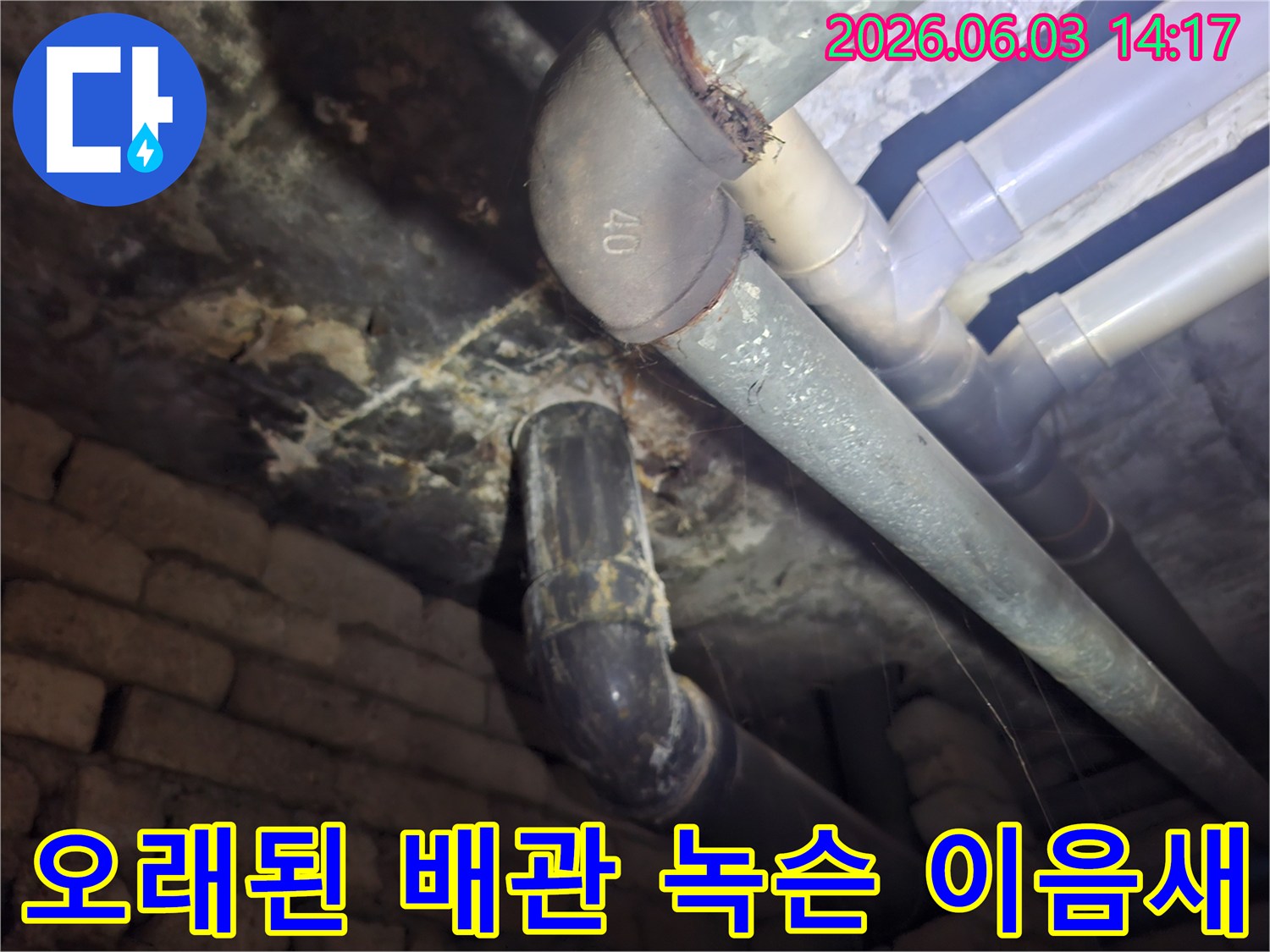 주택 지하의 오래되어 녹슬고 낡은 배관 이음새를-누수 발생 가능성을 확인하기 위해-전문가가 촬영한 현장 사진