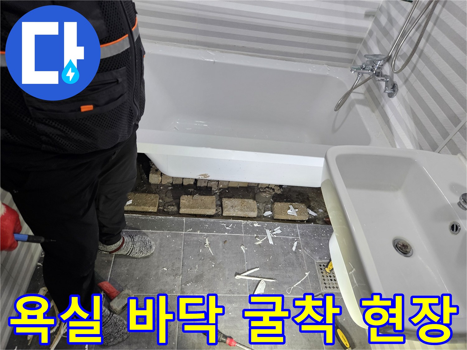 욕조 탈거 후 노출된 배관과 흩어진 타일 조각들