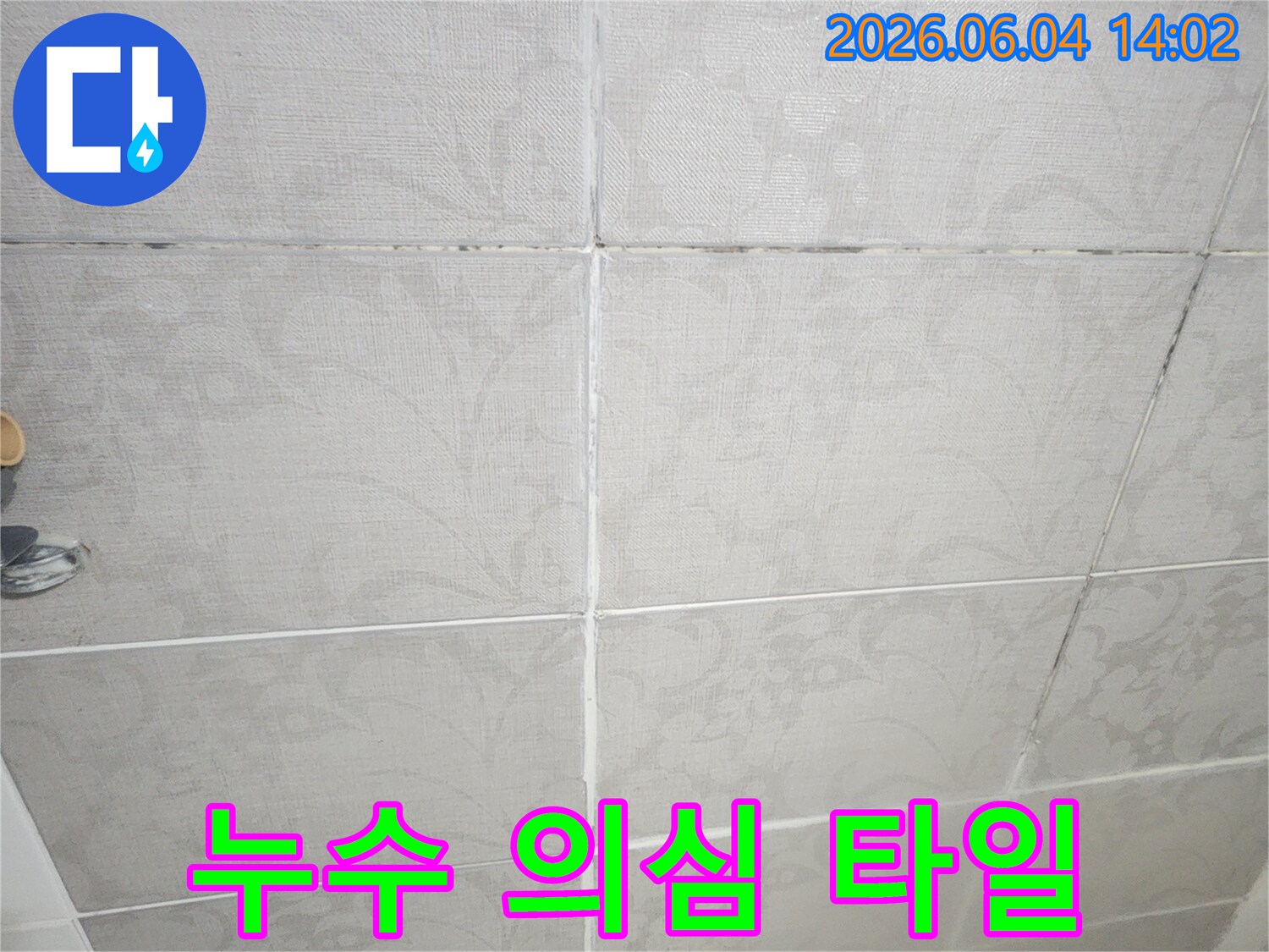 욕실 벽면의 타일이 들떠있고-줄눈에 곰팡이가 생긴 모습으로-누수가 의심되는 상황을 보여줍니다.